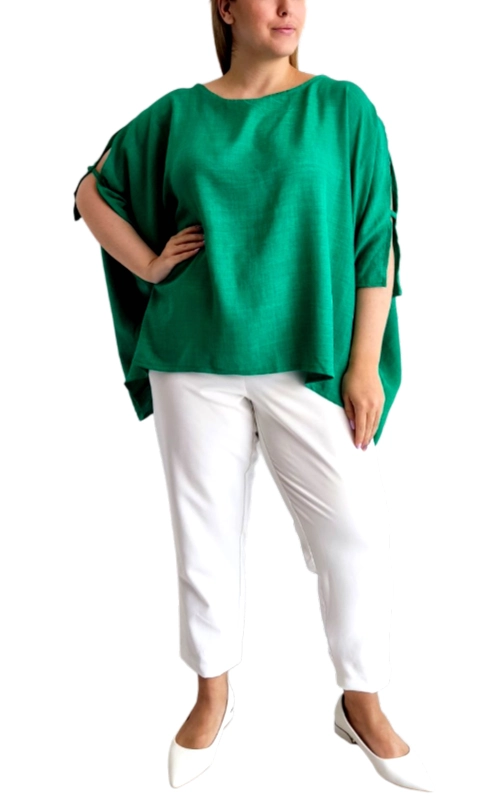Αυτή η εντυπωσιακή μπλούζα σε ζωηρό πράσινο σμαραγδί χρώμα αποτελεί την ιδανική προσθήκη στη καλοκαιρινή σας γκαρνταρόμπα. Με φαρδιά, oversized γραμμή και ασύμμετρο τελείωμα, προσφέρει άνεση και κομψότητα σε κάθε σας εμφάνιση. Τα ιδιαίτερα μανίκια με ανοίγματα στους βραχίονες προσθέτουν μια μοντέρνα πινελιά, ενώ η λαιμόκοψη τύπου boat neck χαρίζει θηλυκότητα χωρίς να αποκαλύπτει υπερβολικά. Ο ελαφρύς, αέρινος ύφασμα ρέει κομψά γύρω από το σώμα, δημιουργώντας μια κολακευτική σιλουέτα που ταιριάζει σε κάθε σωματότυπο. Συνδυάστε την με λευκά παντελόνια όπως στην εικόνα για μια φρέσκια καλοκαιρινή εμφάνιση, ή με τζιν για πιο casual περιστάσεις. Κατάλληλη τόσο για το γραφείο όσο και για απογευματινές εξόδους, αυτή η πολυμορφική μπλούζα προσαρμόζεται εύκολα σε διαφορετικά στυλ και περιστάσεις. Η εύκολη συντήρηση και η διαχρονική κομψότητά της την καθιστούν απαραίτητο κομμάτι για κάθε γυναικεία γκαρνταρόμπα.