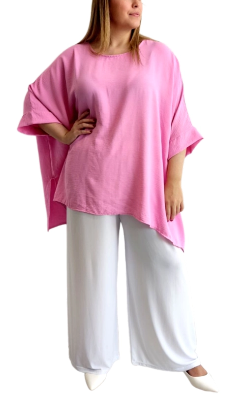 Αυτή η εντυπωσιακή μπλούζα σε απαλό ροζ χρώμα αποτελεί την ιδανική προσθήκη στη καλοκαιρινή σας γκαρνταρόμπα. Με φαρδιά, άνετη γραμμή τύπου oversized και χαλαρά, φαρδιά μανίκια που πέφτουν ελαφρώς κάτω από τους αγκώνες, προσφέρει μια κομψή αίσθηση άνεσης. Το ασύμμετρο τελείωμα στο κάτω μέρος δημιουργεί μια ενδιαφέρουσα σιλουέτα που κολακεύει κάθε σωματότυπο. Κατασκευασμένη από ελαφρύ, αεράτο ύφασμα που επιτρέπει στο δέρμα να αναπνέει, είναι ιδανική για τις ζεστές καλοκαιρινές ημέρες ή ως στυλάτο κομμάτι για τις βραδινές εξόδους. Συνδυάζεται τέλεια με λευκά φαρδιά παντελόνια όπως στη φωτογραφία, αλλά και με τζιν, κολάν ή φούστες. Η απαλή ροζ απόχρωση είναι διαχρονική και θηλυκή, προσθέτοντας φωτεινότητα στο look σας. Το στρογγυλό λαιμόκοψη και οι καθαρές γραμμές του σχεδίου την καθιστούν εύκολη στο συνδυασμό, ενώ η χαλαρή εφαρμογή της προσφέρει άνεση χωρίς συμβιβασμούς στο στυλ. Ιδανική επιλογή για καθημερινές εμφανίσεις με στυλ ή για χαλαρές βραδινές εξόδους.