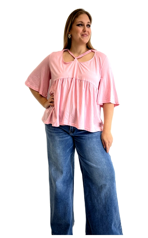 Ανακαλύψτε αυτή την υπέροχη κοντομάνικη μπλούζα σε απαλό ροζ χρώμα, που συνδυάζει άνεση και στυλ σε ένα μοναδικό σχέδιο. Η baby doll γραμμή της δημιουργεί μια ρέουσα, φαρδιά σιλουέτα που κολακεύει κάθε σώμα, ενώ το ελαφρύ, απαλό ύφασμα εξασφαλίζει άνεση καθ\u0027 όλη τη διάρκεια της ημέρας. Το ιδιαίτερο στοιχείο που ξεχωρίζει αυτή τη μπλούζα είναι ο μοναδικός λαιμός της, με λεπτές διακοσμητικές λωρίδες που δημιουργούν ένα εντυπωσιακό cut\u002Dout εφέ, προσδίδοντας έναν αέρα κομψότητας. Τα φαρδιά, κοντά μανίκια με βολάν προσθέτουν ρομαντική διάθεση, ενώ η empire γραμμή κάτω από το στήθος δίνει ένα ιδιαίτερα κολακευτικό αποτέλεσμα για plus size σιλουέτες. Μπορεί να φορεθεί με φαρδύ τζιν παντελόνι για ένα casual καθημερινό look, αλλά και με λευκό παντελόνι ή φούστα για πιο περιποιημένες εμφανίσεις. Ιδανική για καλοκαιρινές εξόδους, ψώνια ή βόλτες, αυτή η μπλούζα είναι η τέλεια επιλογή για κάθε γυναίκα που θέλει να συνδυάσει άνεση και θηλυκότητα.