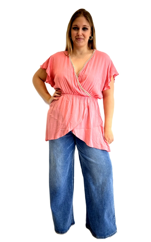 Ανακαλύψτε αυτή την υπέροχη κοντομάνικη μπλούζα σε ζεστό κοραλί χρώμα, ιδανική για γυναίκες plus size που αγαπούν το στυλ και την άνεση. Η μπλούζα διαθέτει κρουαζέ σχεδιασμό με βαθύ V\u002Dλαιμόκοψη, η οποία κοσμείται από μια λεπτή χρυσή αλυσίδα που προσθέτει έναν αέρα πολυτέλειας και κομψότητας. Τα βολάν μανίκια δίνουν ρομαντική και θηλυκή διάσταση στο σύνολο, ενώ η ελαστική μέση τονίζει τη σιλουέτα χαρίζοντας κολακευτική εφαρμογή σε κάθε σώμα. Το ασύμμετρο τελείωμα στο κάτω μέρος της μπλούζας προσφέρει ένα μοντέρνο και δυναμικό αποτέλεσμα. Το ελαφρύ, ρέον ύφασμα εξασφαλίζει άνεση καθ\u0027 όλη τη διάρκεια της ημέρας. Μπορεί να φορεθεί με φαρδιά τζιν παντελόνα για ένα casual chic look, αλλά και με λευκό παντελόνι ή φούστα για πιο επίσημες περιστάσεις. Ιδανική επιλογή για εξόδους, καφέ με φίλες ή ακόμα και για δουλειά.