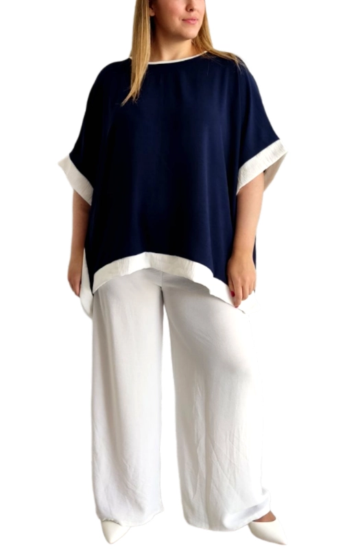 Αυτή η κομψή μπλούζα τύπου πόντσο σε βαθύ ναυτικό μπλε με λευκές λεπτομέρειες αποτελεί την ιδανική προσθήκη στη καλοκαιρινή σας γκαρνταρόμπα. Ο φαρδύς, άνετος σχεδιασμός της με τα χαλαρά μανίκια νυχτερίδα προσφέρει απαράμιλλη άνεση, ενώ η αντίθεση του σκούρου υφάσματος με το λευκό τελείωμα στον λαιμό και στα μανίκια δημιουργεί μια διαχρονική ναυτική αισθητική. Κατασκευασμένη από ελαφρύ, αεράτο ύφασμα που επιτρέπει την κυκλοφορία του αέρα τις ζεστές μέρες, διατηρώντας σας δροσερή και κομψή. Συνδυάζεται τέλεια με λευκά φαρδιά παντελόνια όπως αυτά της φωτογραφίας για μια εκλεπτυσμένη εμφάνιση, ιδανική για καλοκαιρινές βόλτες, απογευματινούς καφέδες ή ακόμα και για χαλαρές επαγγελματικές συναντήσεις. Η ασύμμετρη γραμμή στο τελείωμά της προσθέτει μια μοντέρνα πινελιά, ενώ το πολυμορφικό της στυλ την καθιστά κατάλληλη για διάφορους σωματότυπους. Ένα ευέλικτο κομμάτι που μπορεί εύκολα να μεταμορφωθεί από πρωινό σε βραδινό ντύσιμο με τα κατάλληλα αξεσουάρ.