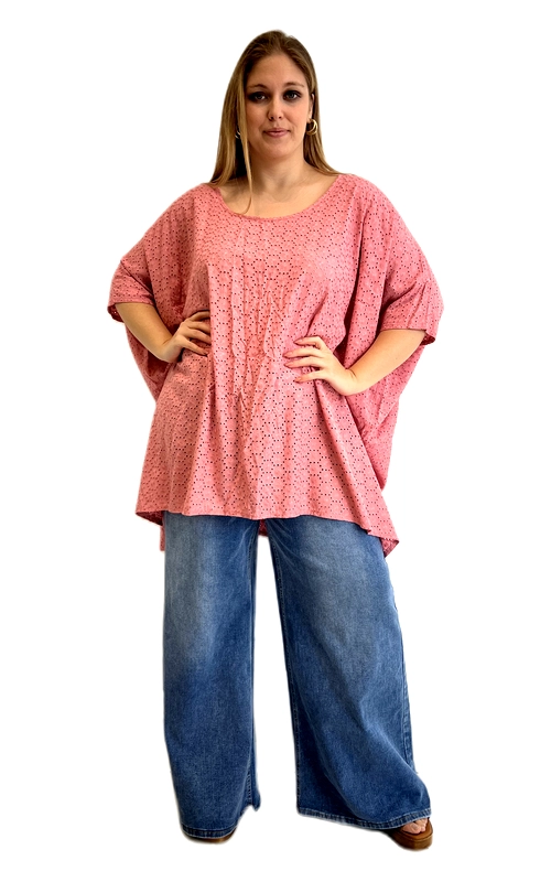 Ανακαλύψτε τη χαρά της άνεσης και του στυλ με αυτή την υπέροχη κοντομάνικη μπλούζα σε ζεστό σομονί χρώμα, ιδανική για plus size σιλουέτες. Το κύριο χαρακτηριστικό της είναι το εντυπωσιακό διάτρητο σχέδιο broderie anglaise που καλύπτει ολόκληρη την επιφάνεια, δημιουργώντας ένα κομψό και αέρινο αποτέλεσμα. Η oversized γραμμή της με τα ευρύχωρα μανίκια τύπου νυχτερίδα εξασφαλίζει απόλυτη ελευθερία κινήσεων, ενώ το στρογγυλό ντεκολτέ προσθέτει μια θηλυκή πινελιά. Το μήκος της πέφτει κομψά στο ισχίο, καλύπτοντας αρμονικά τις καμπύλες. Μπορεί να φορεθεί με φαρδιά τζιν παντελόνια, όπως στην εικόνα, για ένα casual chic look, αλλά και με λευκό παντελόνι ή φούστα για πιο επίσημες εμφανίσεις. Ιδανική για καλοκαιρινές εξόδους, βόλτες στην πόλη ή χαλαρές συναντήσεις με φίλους. Ένα must\u002Dhave κομμάτι που συνδυάζει άνεση και κομψότητα για κάθε γυναίκα που αγαπά το στυλ χωρίς συμβιβασμούς.
