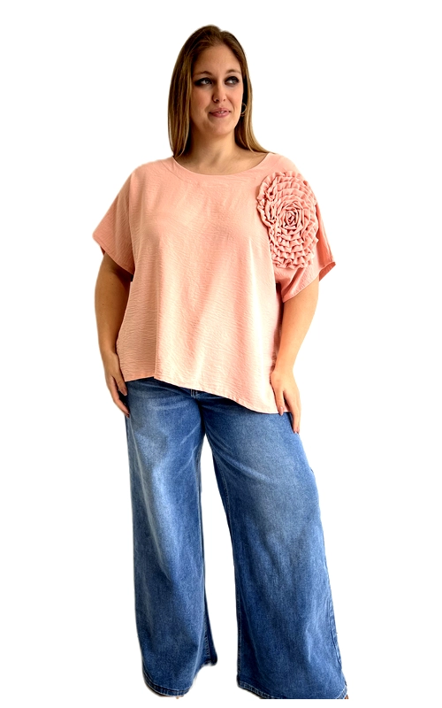 Μια υπέροχη κοντομάνικη μπλούζα σε απαλό σομόν χρώμα, ιδανική για γυναίκες plus size που αγαπούν τον συνδυασμό άνεσης και στυλ. Το κύριο χαρακτηριστικό της είναι το εντυπωσιακό τρισδιάστατο λουλούδι που κοσμεί το μπροστινό μέρος, στο ίδιο σομόν χρώμα, προσδίδοντας έναν ρομαντικό και θηλυκό χαρακτήρα. Η φαρδιά, oversize γραμμή της εξασφαλίζει άνετη εφαρμογή, ενώ η ελαφριά υφή της την καθιστά ιδανική για τις ζεστές εποχές. Ο στρογγυλός λαιμός και τα κοντά μανίκια συμπληρώνουν το καθημερινό αλλά περιποιημένο ύφος της. Μπορεί να φορεθεί με φαρδιά τζιν παντελόνια σε μπλε ντένιμ, όπως φαίνεται στη φωτογραφία, για ένα casual chic αποτέλεσμα, αλλά και με λευκές ή μπεζ παντελόνες για μια πιο κομψή εμφάνιση. Κατάλληλη για καθημερινές εξόδους, καφέ με φίλες ή ακόμα και για χαλαρές επαγγελματικές συναντήσεις. Μια μπλούζα που συνδυάζει τέλεια την άνεση με την κομψότητα, αναδεικνύοντας τη θηλυκή σιλουέτα με χάρη και αυτοπεποίθηση.