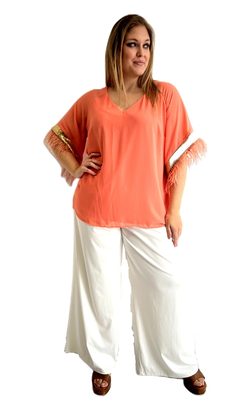 Ανακαλύψτε αυτή την εντυπωσιακή κοντομάνικη μπλούζα σε ζωηρό κοραλί χρώμα, που αποπνέει κομψότητα και θηλυκότητα. Η oversized γραμμή της προσφέρει άνεση και ελευθερία κινήσεων, ενώ ταυτόχρονα κολακεύει κάθε σιλουέτα, ιδανική για plus size γυναίκες που αγαπούν το στυλ χωρίς συμβιβασμούς. Το κύριο χαρακτηριστικό της μπλούζας είναι τα εντυπωσιακά μανίκια της, διακοσμημένα με πολυτελή φτερά σε τόνους κοραλί και λευκό, που της προσδίδουν έναν glamorous χαρακτήρα. Η λεπτομέρεια αυτή τη μετατρέπει από απλή καθημερινή επιλογή σε ένα statement κομμάτι που τραβά όλα τα βλέμματα. Ο V\u002Dλαιμός ολοκληρώνει αρμονικά το σχέδιο, δίνοντας μια επιμηκυντική γραμμή. Μπορεί να φορεθεί με λευκή παλάτσο παντελόνα για ένα κομψό καλοκαιρινό σύνολο, ιδανικό για βραδινές εξόδους, cocktail parties ή καλοκαιρινές εκδηλώσεις. Συνδυάστε την με ψηλοτάκουνα σανδάλια για να ολοκληρώσετε ένα αξέχαστο look.