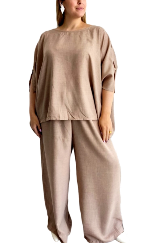 Κομψό σετ δύο τεμαχίων σε υπέροχη μπεζ απόχρωση, ιδανικό για άνετες αλλά στιλάτες εμφανίσεις. Η φαρδιά μπλούζα με χαλαρή γραμμή διαθέτει στρογγυλή λαιμόκοψη και φαρδιά μανίκια μέχρι τον αγκώνα με ιδιαίτερες λεπτομέρειες στα άκρα τους, προσφέροντας κολακευτική εφαρμογή σε κάθε σωματότυπο. Συνδυάζεται με φαρδύ παντελόνι ίδιας απόχρωσης που χαρίζει άνεση και ελευθερία κινήσεων. Κατασκευασμένο από υψηλής ποιότητας λινό ύφασμα που αναπνέει, αυτό το σύνολο είναι ιδανικό για τις ζεστές καλοκαιρινές ημέρες αλλά και για μεταβατικές εποχές. Μπορεί να φορεθεί τόσο για καθημερινές βόλτες και ψώνια όσο και για απογευματινούς καφέδες ή χαλαρά δείπνα. Συνδυάστε το με διακριτικά κοσμήματα και πέδιλα για μια κομψή εμφάνιση ή με σανδάλια για πιο casual look. Η διαχρονική σχεδίαση και το ουδέτερο χρώμα το καθιστούν απαραίτητο κομμάτι για κάθε γυναικεία γκαρνταρόμπα.