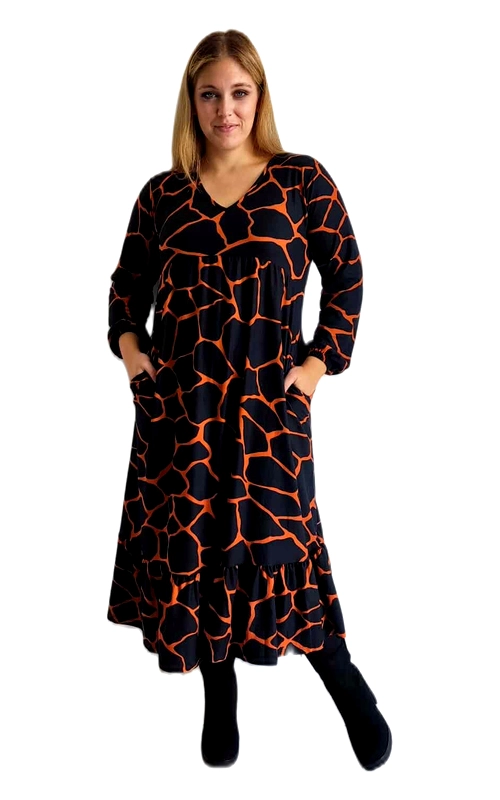 Αυτό το εντυπωσιακό maxi φόρεμα συνδυάζει κομψότητα και άνεση για τις χειμωνιάτικες σας εμφανίσεις. Σε μαύρο φόντο με έντονα πορτοκαλί γεωμετρικά μοτίβα που θυμίζουν κυψέλη, δημιουργεί μια εντυπωσιακή αντίθεση χρωμάτων που τραβάει αμέσως την προσοχή. Το φόρεμα διαθέτει χαλαρή γραμμή με V\u002Dλαιμόκοψη και μακριά μανίκια, προσφέροντας άνετη εφαρμογή που κολακεύει κάθε σωματότυπο. Ιδιαίτερα λειτουργικό με τις πλαϊνές τσέπες, που προσθέτουν πρακτικότητα στο στυλ σας. Το μήκος του φτάνει μέχρι τον αστράγαλο, δημιουργώντας μια θηλυκή σιλουέτα που μπορεί να συνδυαστεί τέλεια με μποτάκια ή μπότες για καθημερινές εμφανίσεις, αλλά και με ψηλοτάκουνα για πιο επίσημες περιστάσεις. Το φαρδύ κόψιμο στο κάτω μέρος προσφέρει άνεση στην κίνηση, ενώ η ελαφρώς ψηλόμεση γραμμή τονίζει τη μέση. Ιδανικό για περιστάσεις από το πρωί μέχρι το βράδυ, αποτελεί ένα ευέλικτο κομμάτι που θα αναβαθμίσει τη χειμερινή σας γκαρνταρόμπα.