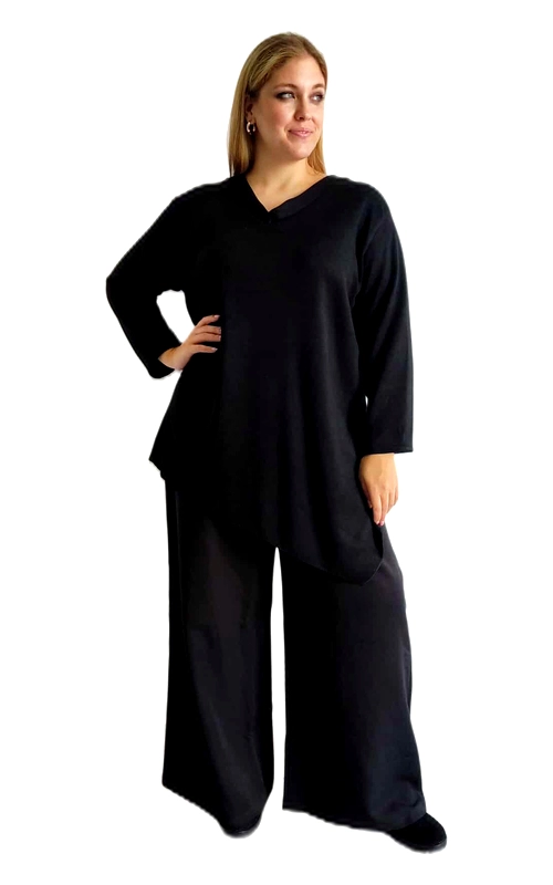 Η μπλούζα διαθέτει κομψό λαιμό σε σχήμα V και μακριά φαρδιά μανίκια που προσφέρουν ελευθερία κινήσεων. Ο ασύμμετρος σχεδιασμός της δημιουργεί μια κολακευτική γραμμή που αγκαλιάζει το σώμα, ενώ το βαθύ μαύρο χρώμα προσθέτει διαχρονική κομψότητα. Το παντελόνι παλάτσο με την άνετη και φαρδιά γραμμή συμπληρώνει τέλεια το σύνολο, χαρίζοντας μια αίσθηση πολυτέλειας και ρευστότητας στην κίνηση. Κατασκευασμένο από μαλακό, υψηλής ποιότητας ύφασμα που αγκαλιάζει το σώμα χωρίς να περιορίζει. Αυτό το σύνολο είναι ιδανικό για επαγγελματικές συναντήσεις, βραδινές εξόδους ή ειδικές περιστάσεις. Μπορεί να συνδυαστεί με διακριτικά κοσμήματα και ψηλοτάκουνα παπούτσια για μια πιο επίσημη εμφάνιση, ή με μοντέρνα αξεσουάρ για ένα σύγχρονο καθημερινό στυλ. Διατίθεται σε διάφορα μεγέθη για να ταιριάζει σε κάθε σωματότυπο.