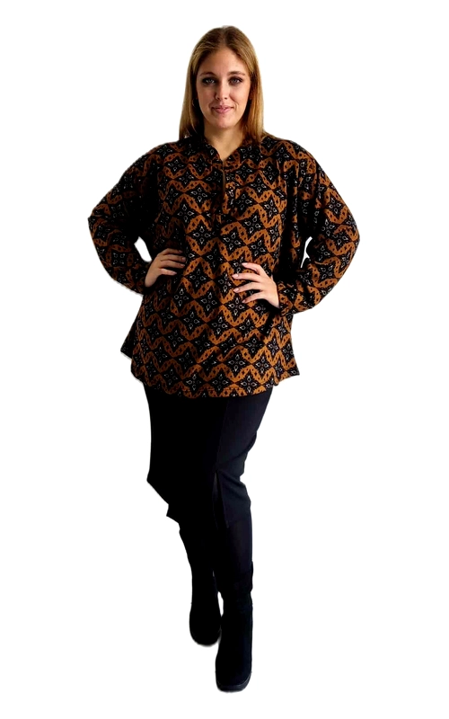 Αυτή η κομψή μακρυμάνικη μπλούζα σε συνδυασμό χρωμάτων καφέ ταμπά και μαύρου διαθέτει ένα εντυπωσιακό γεωμετρικό μοτίβο που προσδίδει ιδιαίτερο χαρακτήρα στο ένδυμα. Με λαιμόκοψη τύπου μάο και κουμπιά στο μπροστινό μέρος, προσφέρει άνεση και στυλ για καθημερινή χρήση. Η φαρδιά γραμμή της κολακεύει όλους τους σωματότυπους, ενώ τα μακριά μανίκια την καθιστούν ιδανική επιλογή για τις δροσερές ημέρες του φθινοπώρου και του χειμώνα. Συνδυάστε την με σκούρο μπλε ή μαύρο παντελόνι για ένα κομψό καθημερινό σύνολο που μπορεί να φορεθεί τόσο στο γραφείο όσο και σε απογευματινές εξόδους. Το υφασμάτινο υλικό της εξασφαλίζει άνεση καθ\u0027 όλη τη διάρκεια της ημέρας, ενώ το διαχρονικό σχέδιό της θα παραμείνει στη μόδα για πολλές σεζόν. Ιδιαίτερο χαρακτηριστικό αποτελεί η χαλαρή εφαρμογή που προσφέρει ελευθερία κινήσεων, χωρίς να χάνει τη θηλυκή της γραμμή.