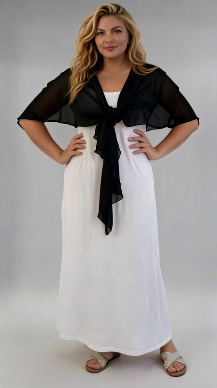 Μπολερό μαύρο καλοκαιρινό plus size - BOL122 | Candiashop Boutique, Ένα κομψό και θηλυκό καλοκαιρινό μπολερό σε βαθύ μαύρο χρώμα, ιδανικό για γυναίκες plus size που αναζητούν στυλ και άνεση. Κατασκευασμένο από ελαφριά, διαφανή σιφόν ύφανση, προσφέρει μια αέρινη και ρομαντική αίσθηση, τέλεια για τις ζεστές καλοκαιρινές μέρες. Το ιδιαίτερο χαρακτηριστικό του είναι το κορδόνι δέσιμο στο μπροστινό μέρος, που δημιουργεί ένα κομψό φιόγκο. Τα φαρδιά μανίκια τύπου cape πέφτουν χαλαρά στους ώμους, δίνοντας μια ρευστή και θηλυκή σιλουέτα που κολακεύει κάθε σώμα. Μπορεί να φορεθεί πάνω από φορέματα, όπως το λευκό maxi φόρεμα της εικόνας, αλλά και με παντελόνια ή φούστες για έξοδο, βόλτα ή καλοκαιρινές εκδηλώσεις. Συνδυάζει την απλότητα με την κομψότητα, καθιστώντας το ένα must-have κομμάτι για κάθε καλοκαιρινή γκαρνταρόμπα.