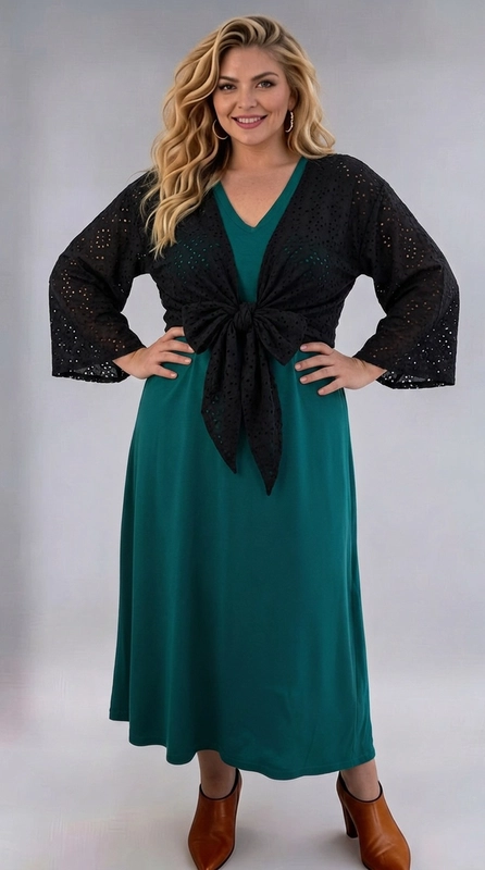 Μπολερό μαύρο καλοκαιρινό plus size - BOL126 | Candiashop Boutique, Ανακαλύψτε το απόλυτο καλοκαιρινό αξεσουάρ με αυτό το εντυπωσιακό μπολερό plus size σε βαθύ μαύρο χρώμα, που θα μεταμορφώσει κάθε σας εμφάνιση. Κατασκευασμένο από ύφασμα με διάτρητο σχέδιο broderie anglaise, αποπνέει κομψότητα και θηλυκότητα, ενώ παράλληλα εξασφαλίζει άνεση κατά τους ζεστούς καλοκαιρινούς μήνες. Το ιδιαίτερο χαρακτηριστικό του είναι ο δέσιμος στη μέση με κόμπο, που δημιουργεί μια κολακευτική σιλουέτα και τονίζει τη γυναικεία φιγούρα. Τα μανίκια τρία τέταρτα με φαρδύ άνοιγμα στο τελείωμα προσδίδουν ένα αέρινο, ρομαντικό ύφος. Μπορεί να φορεθεί πάνω από φορέματα, όπως φαίνεται εδώ με ένα μακρύ φόρεμα σε βαθύ πράσινο χρώμα, αλλά και πάνω από απλά μονόχρωμα σύνολα για να τους δώσετε έναν πιο εκλεπτυσμένο τόνο. Ιδανικό για βραδινές εξόδους, καλοκαιρινές εκδηλώσεις ή ακόμα και για ένα κομψό beach look.