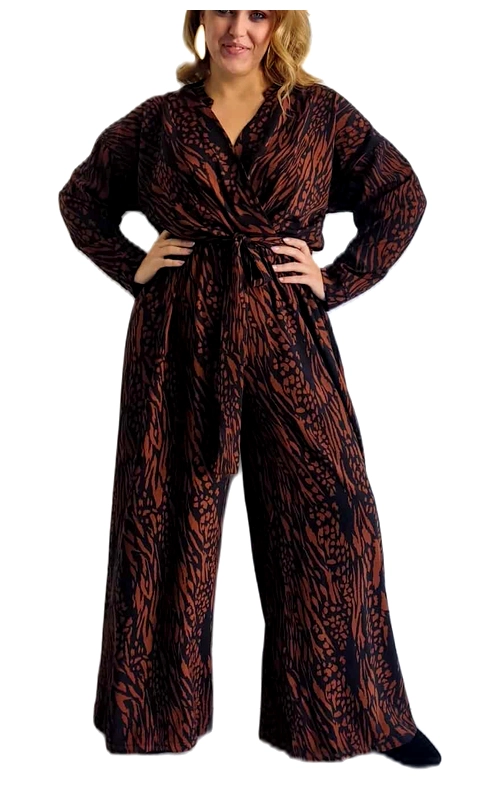 Κομψή ολόσωμη φόρμα σε plus size με εντυπωσιακό μοτίβο animal print σε αποχρώσεις τερακότα και μαύρου. Η φόρμα διαθέτει φαρδιά παντελόνα που χαρίζει άνεση και κομψότητα, ενώ το κρουαζέ μπούστο με V λαιμόκοψη αναδεικνύει τη σιλουέτα με κολακευτικό τρόπο. Τα μακριά φαρδιά μανίκια προσφέρουν κάλυψη και στυλ, ενώ η ζώνη στη μέση τονίζει τις καμπύλες δημιουργώντας μια αρμονική εμφάνιση. Ιδανική επιλογή για βραδινές εξόδους, επίσημες περιστάσεις ή ακόμα και για ένα κομψό επαγγελματικό look όταν συνδυαστεί με ένα σακάκι. Μπορεί να φορεθεί με ψηλοτάκουνα μποτάκια ή γόβες για ένα εντυπωσιακό αποτέλεσμα. Το ρευστό ύφασμα αγκαλιάζει το σώμα χαρίζοντας άνεση και κίνηση, ενώ το τολμηρό μοτίβο προσθέτει μια δυναμική νότα στην εμφάνισή σας. Ένα πολυμορφικό κομμάτι που θα αναβαθμίσει τη γκαρνταρόμπα σας και θα σας χαρίσει αυτοπεποίθηση σε κάθε σας εμφάνιση.