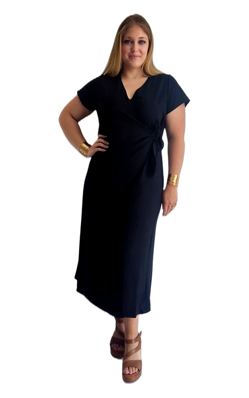 Η κομψή αυτή γυναικεία ολόσωμη φόρμα plus size σε βαθύ μαύρο χρώμα αποτελεί μια διαχρονική επιλογή για κάθε γυναίκα που αναζητά στυλ και άνεση. Με το χαρακτηριστικό κρουαζέ ντεκολτέ σε σχήμα V και το δέσιμο στη μέση με ζωνάκι, δημιουργεί μια κολακευτική σιλουέτα που αναδεικνύει το γυναικείο σώμα. Οι κοντές μανσέτες και η midi γραμμή της προσφέρουν μια αίσθηση εκλεπτυσμένης κομψότητας, ενώ το ελαφρώς ασύμμετρο τελείωμα προσθέτει μια μοντέρνα πινελιά. Η ευέλικτη εφαρμογή της την καθιστά ιδανική τόσο για επαγγελματικές όσο και για καθημερινές ή βραδινές εξόδους. Μπορεί να φορεθεί με πλατφόρμες ή γόβες για ένα πιο επίσημο look, ή με sneakers για μια πιο casual εμφάνιση. Συνδυάστε τη με χρυσά αξεσουάρ, όπως βραχιόλια και σκουλαρίκια, για να αναδείξετε τη φυσική σας κομψότητα. Ιδανική επιλογή για γυναίκες plus size που επιθυμούν να συνδυάσουν άνεση και στυλ σε ένα μοναδικό ένδυμα.