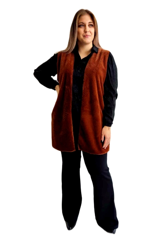 Αυτό το κομψό γυναικείο γιλέκο σε πλούσιο καφέ\u002Dτερακότα χρώμα αποτελεί την ιδανική προσθήκη στη χειμερινή σας γκαρνταρόμπα. Κατασκευασμένο από μαλακό υλικό που μοιάζει με φλις ή βελούδο, προσφέρει εξαιρετική ζεστασιά χωρίς να προσθέτει όγκο. Το γιλέκο διαθέτει απλή, κομψή γραμμή χωρίς κουμπιά ή φερμουάρ, επιτρέποντας άνετη εφαρμογή και ελευθερία κινήσεων. Συνδυάστε το με μαύρο πουκάμισο και παντελόνι για ένα κομψό επαγγελματικό λουκ, όπως παρουσιάζεται στην εικόνα, ή φορέστε το πάνω από πλεκτά για καθημερινές εμφανίσεις. Το μεσαίο μήκος του το καθιστά ιδανικό για όλες τις σωματότυπους, ενώ η απαλή υφή του προσθέτει μια πινελιά πολυτέλειας σε κάθε εμφάνιση. Ιδανικό για τις μεταβατικές εποχές, αυτό το ευέλικτο γιλέκο μπορεί να φορεθεί από το φθινόπωρο έως την άνοιξη, προσφέροντας διαχρονικό στυλ και άνεση. Η απλή σχεδίαση του επιτρέπει αμέτρητους συνδυασμούς, καθιστώντας το απαραίτητο κομμάτι για κάθε γυναικεία γκαρνταρόμπα.
