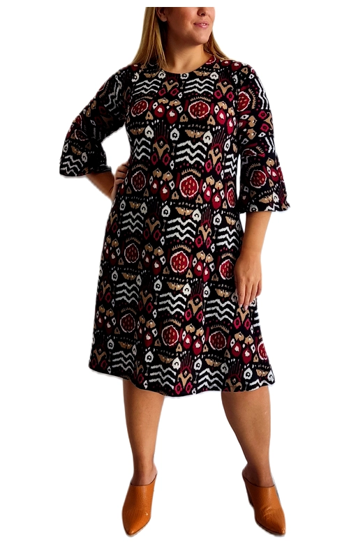 Αυτό το κομψό χειμωνιάτικο φόρεμα σε plus size είναι ιδανικό για τη γυναίκα που αγαπά τα έντονα μοτίβα και τα ζωηρά χρώματα. Με φόντο μαύρο, διακοσμείται με εντυπωσιακά γεωμετρικά και φολκλόρ μοτίβα σε αποχρώσεις κόκκινου, λευκού και μπεζ, δημιουργώντας ένα μοναδικό οπτικό αποτέλεσμα. Τα ζιγκ\u002Dζαγκ σχέδια εναλλάσσονται με κυκλικά μοτίβα που θυμίζουν παραδοσιακά υφαντά. Η άνετη γραμμή Α χαρίζει κολακευτική εφαρμογή, ενώ τα μανίκια 3/4 με το ελαφρώς καμπανέ τελείωμα προσθέτουν θηλυκότητα και στυλ. Το μήκος του φορέματος που φτάνει κάτω από το γόνατο είναι ιδανικό για κάθε σωματότυπο. Φορέστε το με καφέ μποτάκια για καθημερινές εμφανίσεις ή αναβαθμίστε το με ψηλοτάκουνες μπότες και κοσμήματα για βραδινές εξόδους. Κατάλληλο τόσο για το γραφείο όσο και για περιστασιακές συναντήσεις, αυτό το φόρεμα συνδυάζει άνεση και στυλ, αποτελώντας ένα ευέλικτο κομμάτι για τη χειμερινή σας γκαρνταρόμπα.