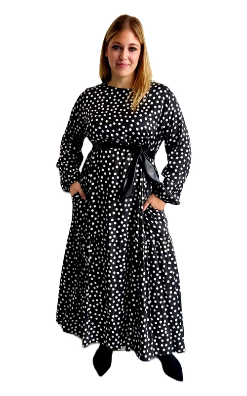 Αυτό το κομψό φόρεμα σε μαύρο χρώμα με λευκό πουά μοτίβο αποτελεί μια εξαιρετική επιλογή για τη χειμερινή σας γκαρνταρόμπα. Διαθέτει φαρδιά γραμμή με μακριά, άνετα μανίκια που προσφέρουν ζεστασιά κατά τους κρύους μήνες. Η μεσάτη σιλουέτα τονίζεται από μια κομψή ζώνη σε μαύρο γυαλιστερό ύφασμα που δένει στη μέση, χαρίζοντας θηλυκότητα και κολακεύοντας κάθε σωματότυπο. Το φόρεμα έχει μήκος που φτάνει μέχρι τον αστράγαλο, με φαρδιά, ριχτή φούστα που χαρίζει άνεση στις κινήσεις. Διαθέτει πρακτικές πλαϊνές τσέπες, ιδανικές για μικροαντικείμενα. Το διαχρονικό πουά μοτίβο προσδίδει παιχνιδιάρικη διάθεση στο κομμάτι, ενώ ο συνδυασμός μαύρου\u002Dλευκού το καθιστά εύκολο στον συνδυασμό. Φορέστε το με μποτάκια για καθημερινές εμφανίσεις ή με ψηλοτάκουνα για πιο επίσημες περιστάσεις. Ιδανικό για επαγγελματικές συναντήσεις, οικογενειακά γεύματα ή απογευματινές εξόδους. Το ύφασμα είναι ελαφρύ αλλά ζεστό, προσφέροντας άνεση καθ\u0027 όλη τη διάρκεια της ημέρας.