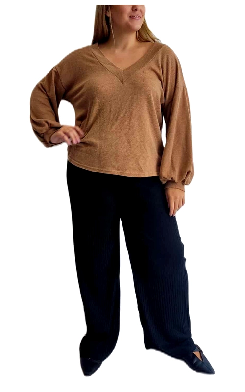 Αυτό το κομψό πουλόβερ σε απόχρωση καμηλό είναι η ιδανική προσθήκη στη φθινοπωρινή και χειμερινή σας γκαρνταρόμπα. Με λαιμόκοψη V που κολακεύει και φαρδιά, άνετη εφαρμογή, προσφέρει στυλ και άνεση για καθημερινή χρήση. Τα φουσκωτά μανίκια με ελαστικές μανσέτες προσθέτουν μια μοντέρνα πινελιά στο κλασικό σχέδιο, ενώ το ελαφρώς κοντύτερο μήκος του το καθιστά ιδανικό για συνδυασμό με παντελόνες υψηλής μέσης, όπως το μαύρο παντελόνι της εικόνας. Το μαλακό υφασμάτινο υλικό προσφέρει ζεστασιά χωρίς να είναι βαρύ, επιτρέποντας άνετες κινήσεις όλη την ημέρα. Συνδυάστε το με τζιν για καθημερινές εξορμήσεις ή με κομψό παντελόνι για επαγγελματικές περιστάσεις. Η διαχρονική του απόχρωση ταιριάζει εύκολα με διάφορα χρώματα και αξεσουάρ, καθιστώντας το ένα ευέλικτο κομμάτι για πολλαπλά σύνολα. Ιδανικό για μεγαλύτερα μεγέθη, προσφέρει κολακευτική εφαρμογή που αναδεικνύει τη σιλουέτα με κομψότητα και στυλ.