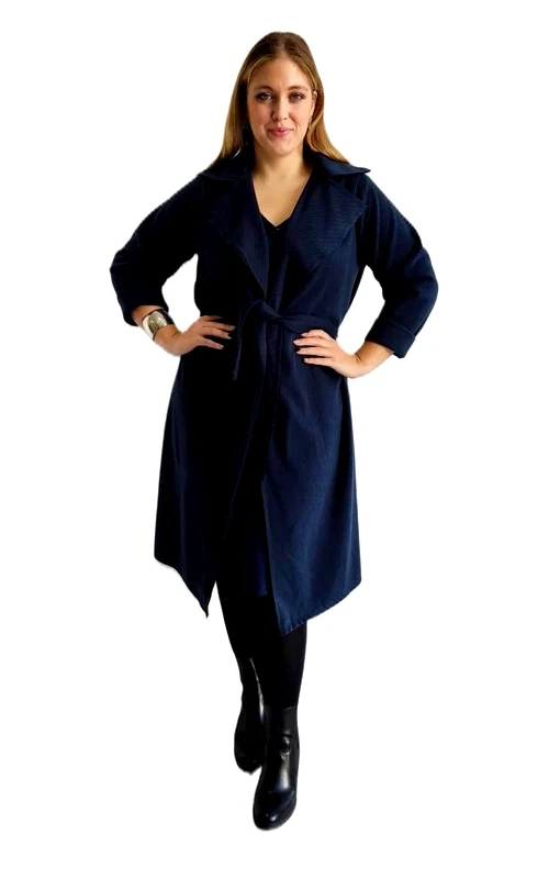 Κομψό γυναικείο παλτό σε βαθύ navy blue χρώμα που αποπνέει διαχρονική κομψότητα και στυλ. Διαθέτει χαλαρή γραμμή με φαρδιά πέτα και ζώνη στη μέση που τονίζει τη σιλουέτα, προσφέροντας μια θηλυκή εμφάνιση. Το μήκος του φτάνει κάτω από το γόνατο, κάνοντάς το ιδανικό για πολλαπλές περιστάσεις. Αυτό το κομψό παλτό μπορεί εύκολα να συνδυαστεί με επαγγελματικά ή καθημερινά σύνολα. Φορέστε το πάνω από ένα μαύρο φόρεμα για το γραφείο ή συνδυάστε το με τζιν και μπότες για μια κομψή καθημερινή εμφάνιση. Το λιτό σχέδιο και η εύκολη εφαρμογή το καθιστούν βασικό κομμάτι για κάθε γυναικεία γκαρνταρόμπα. Η ποιοτική κατασκευή του εξασφαλίζει άνεση και ανθεκτικότητα, ενώ το βαθύ μπλε χρώμα του είναι εύκολο να συνδυαστεί και παραμένει διαχρονικό. Ιδανικό για τις μεταβατικές εποχές της άνοιξης και του φθινοπώρου, αλλά και για ήπιους χειμερινούς μήνες με τα κατάλληλα στρώματα ρούχων από μέσα.