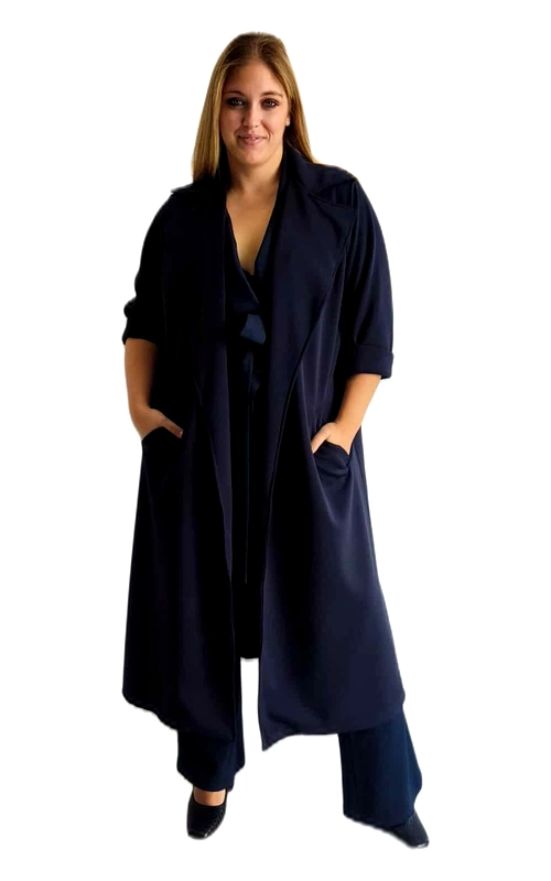 Κομψό μακρύ παλτό σε βαθύ ναυτικό μπλε, ιδανικό για γυναίκες που αναζητούν στυλ και άνεση σε μεγαλύτερα μεγέθη. Το φαρδύ, ρέον σχέδιο χαρίζει μια αέρινη αίσθηση, ενώ οι αναδιπλωμένες μανσέτες στα τρία\u002Dτέταρτα μανίκια προσθέτουν μια διακριτική λεπτομέρεια. Διαθέτει πρακτικές πλαϊνές τσέπες για μικροαντικείμενα και άνετη εφαρμογή που κολακεύει κάθε σιλουέτα. Αυτό το παλτό μπορεί να φορεθεί ανοιχτό για μια χαλαρή εμφάνιση ή με ζώνη για πιο δομημένο αποτέλεσμα. Συνδυάζεται τέλεια με παντελόνια, φορέματα ή φούστες στο ίδιο χρώμα για ένα μονοχρωματικό σύνολο που εντυπωσιάζει. Ιδανικό για επαγγελματικές συναντήσεις, βραδινές εξόδους ή καθημερινές περιστάσεις που απαιτούν κομψότητα. Το ανθεκτικό ύφασμα εξασφαλίζει διαχρονική χρήση, ενώ η minimal αισθητική του το καθιστά απαραίτητο κομμάτι για κάθε γκαρνταρόμπα. Απογειώστε την εμφάνισή σας με αυτό το κομψό παλτό που συνδυάζει στυλ και λειτουργικότητα.
