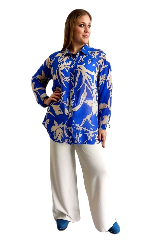 Ανακαλύψτε αυτή την εντυπωσιακή γυναικεία πουκαμίσα plus size που συνδυάζει στυλ και άνεση με αξεπέραστη χάρη. Το ζωηρό μπλε ρουά χρώμα της δημιουργεί την τέλεια βάση για το εντυπωσιακό floral μοτίβο σε αποχρώσεις εκρού, με μεγάλα φυτικά σχέδια και άνθη που απλώνονται σε όλη την επιφάνεια του υφάσματος. Η oversized γραμμή της προσφέρει άνετη εφαρμογή που κολακεύει όλες τις σιλουέτες, ενώ το μακρύ μανίκι και το κλασικό γιακαδάκι με κουμπιά προσδίδουν έναν κομψό, καθημερινό χαρακτήρα. Το μήκος της πουκαμίσας, που φτάνει κάτω από τη μέση, την κάνει ιδανική για να φορεθεί τόσο εντός όσο και εκτός από το παντελόνι. Μπορεί να συνδυαστεί με λευκό παλάτσο παντελόνι για ένα chic, ολοκληρωμένο σύνολο, ιδανικό για καθημερινές εξόδους, επαγγελματικές συναντήσεις ή βραδινές εμφανίσεις. Η ζωντανή παλέτα χρωμάτων της εγγυάται ότι δεν θα περάσετε απαρατήρητες.