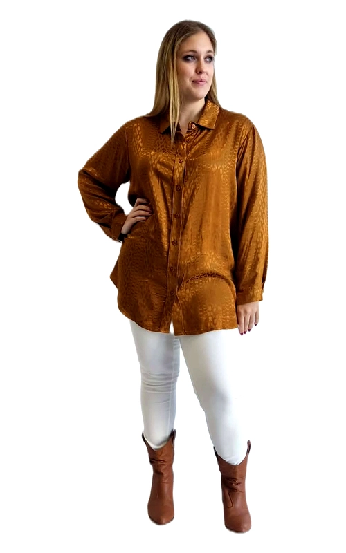 Μια εντυπωσιακή γυναικεία πουκαμίσα σε πλούσια απόχρωση κεχριμπαριού\u002Dκαμηλό, που αποπνέει κομψότητα και στυλ. Το ύφασμά της, με σατινέ υφή και διακριτικό jacquard μοτίβο με floral και γεωμετρικά σχέδια, δημιουργεί μια εκλεπτυσμένη οπτική εντύπωση που ξεχωρίζει. Η γραμμή της είναι oversized και χαλαρή, προσφέροντας άνεση χωρίς να θυσιάζει την αισθητική. Διαθέτει κλασικό γιακά, κουμπιά μπροστά σε ολόκληρο το μήκος και μακριά μανίκια, ενώ το πίσω μέρος είναι ελαφρώς πιο μακρύ, δίνοντας μια σύγχρονη πινελιά. Ιδανική επιλογή για plus size σιλουέτες, χαρίζει αυτοπεποίθηση και άνεση. Μπορεί να φορεθεί με λευκό τζιν και καφέ μπότες για ένα casual\u002Dchic σύνολο, αλλά και με ψηλόμεση φούστα για πιο επίσημες περιστάσεις. Κατάλληλη για καθημερινή χρήση, εξόδους ή επαγγελματικό περιβάλλον, αποτελεί ένα ευέλικτο κομμάτι που αξίζει να έχει κάθε γυναίκα στη γκαρνταρόμπα της.