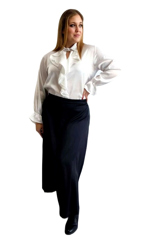 Μια υπέροχη γυναικεία πουκαμίσα σε κλασικό λευκό χρώμα που αναδεικνύει την κομψότητα και τη θηλυκότητα. Το κύριο χαρακτηριστικό της είναι η εντυπωσιακή βολάν λεπτομέρεια στο μπροστινό μέρος, που δημιουργεί έναν ρομαντικό και sophisticated χαρακτήρα. Η σατινέ υφή της υφής της προσδίδει μια πολυτελή αίσθηση, ενώ οι μακριές φαρδιές μανσέτες με βολάν στα μανίκια ολοκληρώνουν το κομψό αποτέλεσμα. Η εφαρμογή είναι ελαφρώς φαρδιά, ιδανική για plus size σιλουέτες, προσφέροντας άνεση χωρίς να χάνει τη γυναικεία γραμμή. Ο λαιμός με το χαρακτηριστικό άνοιγμα κλειδαρότρυπας προσθέτει μια διακριτική αισθησιακή πινελιά. Μπορεί να φορεθεί με μαύρη maxi φούστα για ένα επίσημο look, όπως φαίνεται στην εικόνα, αλλά και με κλασικό παντελόνι για επαγγελματικές εμφανίσεις ή με τζιν για έναν πιο casual συνδυασμό. Ιδανική επιλογή για επαγγελματικές συναντήσεις, επίσημες εκδηλώσεις, αλλά και βραδινές εξόδους που απαιτούν κομψότητα και στυλ.