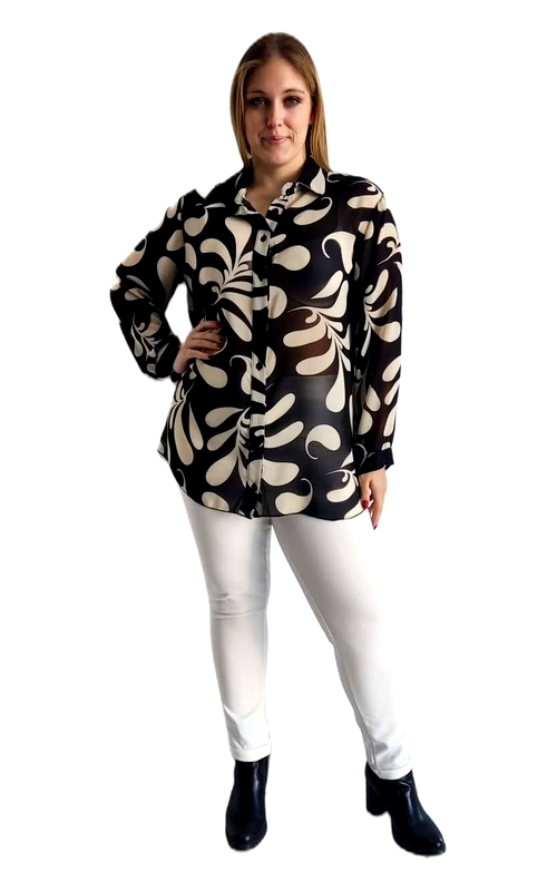Εντυπωσιακή γυναικεία πουκαμίσα plus size με έντολο γραφικό μοτίβο σε μαύρο και εκρού χρώμα, που αποπνέει στυλ και αυτοπεποίθηση. Το τολμηρό σχέδιο με αφηρημένα φυτικά μοτίβα και καμπύλες φόρμες δημιουργεί μια μοντέρνα, καλλιτεχνική αισθητική που ξεχωρίζει. Η γραμμή της είναι χαλαρή και άνετη, με μακριά μανίκια και κλασικό γιακά πουκαμίσου, ενώ το μήκος της πέφτει κάτω από τη μέση, προσφέροντας κομψή κάλυψη. Το ύφασμά της φαίνεται ελαφρύ και ρέον, ιδανικό για καθημερινή χρήση αλλά και για πιο επίσημες περιστάσεις. Μπορεί να φορεθεί με λευκό ή μαύρο παντελόνι για ένα αρμονικό σύνολο, καθώς και με τζιν ή φούστα για πιο casual εμφανίσεις. Ταιριάζει τέλεια με χαμηλά μποτάκια ή γόβες, ανάλογα με την περίσταση. Ιδανική επιλογή για γυναίκες που αναζητούν ένδυμα που συνδυάζει άνεση, στυλ και θηλυκότητα σε μεγαλύτερα νούμερα.