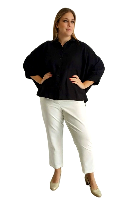 Η γυναικεία plus size πουκαμίσα σε βαθύ μαύρο χρώμα είναι η ιδανική επιλογή για κάθε γυναίκα που αναζητά στυλ και άνεση σε ένα μοναδικό κομμάτι. Το oversized κόψιμό της με φαρδιά, μπαλόν μανίκια τριών τετάρτων προσφέρει μια ιδιαίτερα κολακευτική γραμμή, ενώ το κλασικό γιακαδάκι και το κουμπωτό μπροστινό μέρος δίνουν έναν κομψό, καθημερινό χαρακτήρα. Η κοντή, crop γραμμή της πουκαμίσας τη διαφοροποιεί από τα συνηθισμένα σχέδια, δημιουργώντας μια μοντέρνα σιλουέτα που κολακεύει κάθε σωματότυπο. Μπορεί να φορεθεί με λευκό παντελόνι για ένα κλασικό contrast look, όπως φαίνεται στη φωτογραφία, ή με τζιν παντελόνι για μια πιο casual εμφάνιση. Ταιριάζει εξίσου με φούστα για βραδινές εξόδους ή επαγγελματικές περιστάσεις. Το μονόχρωμο, απλό σχέδιό της την καθιστά ευέλικτη και εύκολη στο συνδυασμό, ενώ το υλικό της φαίνεται ελαφρύ και αναπνεύσιμο, ιδανικό για κάθε εποχή.