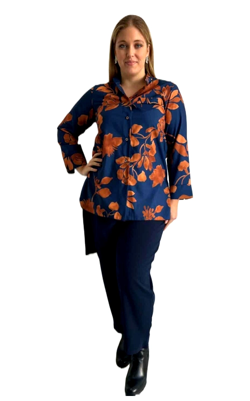 Αυτή η κομψή γυναικεία πουκαμίσα σε μεγάλα μεγέθη συνδυάζει άνεση και στυλ με έναν μοναδικό τρόπο. Το βαθύ ναυτικό μπλε φόντο της αναδεικνύεται υπέροχα από το εντυπωσιακό φλοράλ μοτίβο σε ζεστές αποχρώσεις τερακότα, δημιουργώντας μια εξαιρετική χρωματική αντίθεση. Διαθέτει κλασικό γιακά, μπροστινό κούμπωμα με κουμπιά και άνετα τρία\u002Dτέταρτα μανίκια που κολακεύουν τους βραχίονες. Η χαλαρή γραμμή της πουκαμίσας προσφέρει άνετη εφαρμογή που αγκαλιάζει τη σιλουέτα χωρίς να την περιορίζει, ενώ το μήκος της είναι ιδανικό για να φορεθεί είτε μέσα είτε έξω από το παντελόνι. Συνδυάζεται τέλεια με σκούρα παντελόνια όπως το εικονιζόμενο μπλε, αλλά και με τζιν ή φούστες για ποικιλία στυλ. Ιδανική για επαγγελματικές συναντήσεις, καθημερινές εξόδους ή ακόμα και για πιο επίσημες περιστάσεις όταν συνδυαστεί με τα κατάλληλα αξεσουάρ. Το ζωντανό φλοράλ μοτίβο προσθέτει μια νότα θηλυκότητας και κομψότητας, καθιστώντας αυτή την πουκαμίσα ένα ευέλικτο κομμάτι για κάθε ντουλάπα.