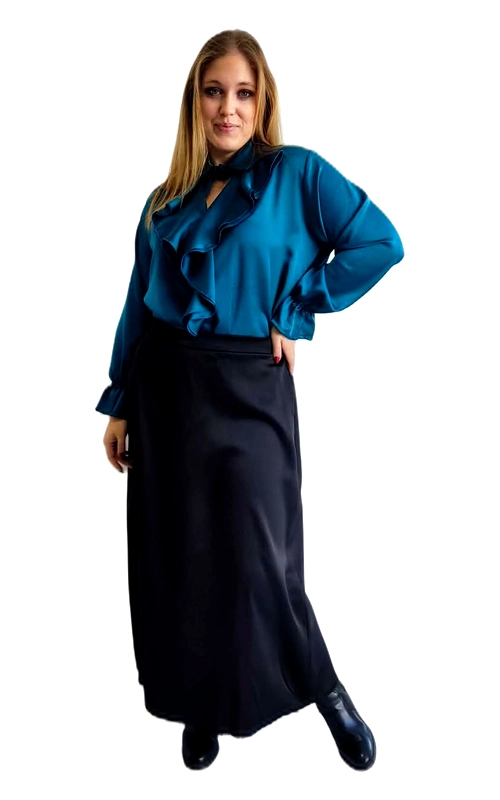 Ανακαλύψτε την τέλεια γυναικεία πουκαμίσα που συνδυάζει κομψότητα και στυλ σε ένα μοναδικό σχέδιο. Σε βαθύ χρώμα πετρόλ, αυτή η εντυπωσιακή μπλούζα διαθέτει ένα ρομαντικό βολάν στο μπροστινό μέρος που ξεκινά από τον λαιμό και κατεβαίνει διαγώνια, δημιουργώντας μια θηλυκή και εκλεπτυσμένη σιλουέτα. Η σατινέ υφή της υφασμάτινης επιφάνειας προσδίδει μια πολυτελή αίσθηση, ενώ τα φαρδιά μανίκια με τις εντυπωσιακές μανσέτες προσθέτουν δραματισμό και χάρη στο σύνολο. Η γραμμή της είναι χαλαρή και άνετη, ιδανική για plus size σώματα, προσφέροντας ελευθερία κινήσεων χωρίς να θυσιάζει το στυλ. Μπορεί να φορεθεί με μαύρη maxi φούστα ή παντελόνι για ένα επαγγελματικό look, αλλά και με δερμάτινο παντελόνι για μια πιο τολμηρή εμφάνιση. Κατάλληλη για επαγγελματικές συναντήσεις, επίσημες εξόδους ή ακόμα και για ένα romantic dinner, αυτή η πουκαμίσα θα σας κάνει να ξεχωρίζετε με κομψότητα και αυτοπεποίθηση.