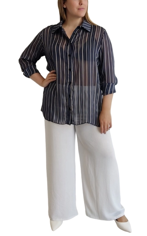 Κομψή ριγέ πουκαμίσα σε μαύρο φόντο με λεπτές κάθετες λευκές ρίγες, κατασκευασμένη από διάφανο, αέρινο ύφασμα που προσφέρει μια εξαιρετικά θηλυκή εμφάνιση. Η ημιδιάφανη υφή της την καθιστά ιδανική για layering, επιτρέποντάς σας να τη συνδυάσετε με τοπ ή μπλούζες από μέσα. Διαθέτει κλασικό γιακά, μανίκια 3/4 που μπορούν να διπλωθούν για πιο casual εμφάνιση και κουμπιά στο μπροστινό μέρος για εύκολο φόρεμα. Η φαρδιά γραμμή της χαρίζει άνεση και κολακεύει κάθε σωματότυπο, ενώ το μήκος της καλύπτει ιδανικά τους γοφούς. Συνδυάζεται τέλεια με λευκά παντελόνια όπως στην εικόνα, αλλά και με τζιν, κολάν ή φούστες. Ιδανική επιλογή για καθημερινές εμφανίσεις στο γραφείο, βραδινές εξόδους ή περιστασιακές συναντήσεις. Η διαχρονική ριγέ σχεδίαση εξασφαλίζει ότι αυτό το κομμάτι θα παραμείνει στη ντουλάπα σας για πολλές σεζόν, προσφέροντας αμέτρητους συνδυασμούς.