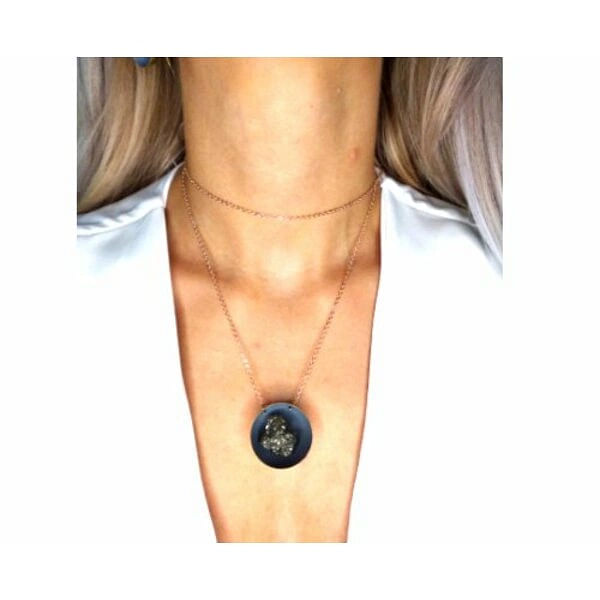 Μεγάλο κολιέ μακρύ με πυρίτη γκρι - 10868, Ανακαλύψτε το μοναδικό χειροποίητο κολιέ με πυρίτη που συνδυάζει τη φυσική ομορφιά του σιδηροπυρίτη με τη σύγχρονη ελληνική αισθητική. Αυτό το εντυπωσιακό μακρύ κολιέ, σχεδιασμένο από την Αικατερίνη Χαλκιαδάκη, αποτελεί την ιδανική επιλογή για γυναίκες που αναζητούν statement κοσμήματα με φυσικές πέτρες.
Το κολιέ διακρίνεται για τον μοναδικό συνδυασμό υλικών και χρωμάτων. Η κεντρική κρεμαστή ενότητα παρουσιάζει έναν γκρι δίσκο από ρητίνη με χρώμα κιμωλίας, που φιλοξενεί έναν λαμπερό σιδηροπυρίτη με μεταλλικές ανταύγειες. Η ορειχάλκινη βάση και αλυσίδα προσφέρουν ανθεκτικότητα και χρυσαφένια απόχρωση που συμπληρώνει αρμονικά τους γήινους τόνους της πέτρας.