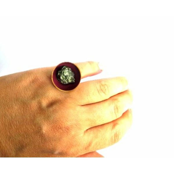 Δαχτυλίδι γυναικείο με πυρίτη medium μπορντό - 10989, Ανακαλύψτε τη μαγεία του χειροποίητου κοσμήματος με αυτό το εντυπωσιακό γυναικείο δαχτυλίδι με πυρίτη σε μπορντό απόχρωση. Σχεδιασμένο από την Ελληνίδα Σχεδιάστρια Κοσμημάτων Αικατερίνη Χαλκιαδάκη, το δαχτυλίδι αυτό συνδυάζει την παραδοσιακή ελληνική τεχνοτροπία με τη σύγχρονη αισθητική.
Το μεγάλο δαχτυλίδι διαθέτει στρογγυλή επιφάνεια σε έντονο μπορντό χρώμα, στο κέντρο της οποίας λάμπει φυσικός σιδηροπυρίτης με το χαρακτηριστικό του χρυσαφί μεταλλικό γυαλάδι. Η βάση από ορείχαλκο προσφέρει σταθερότητα και άνεση στη φορεσιά, ενώ η χειροποίητη κατασκευή εγγυάται τη μοναδικότητα κάθε κομματιού.
Αυτό το statement δαχτυλίδι είναι ιδανικό για να συμπληρώσει τόσο καθημερινά όσο και βραδινά σύνολα, προσδίδοντας μια πινελιά αυθεντικής ελληνικής τέχνης στο στυλ σας. Φυλάσσετε σε στεγνό μέρος και καθαρίζετε με μαλακό πανί για να διατηρήσετε τη λάμψη του κοσμήματος.