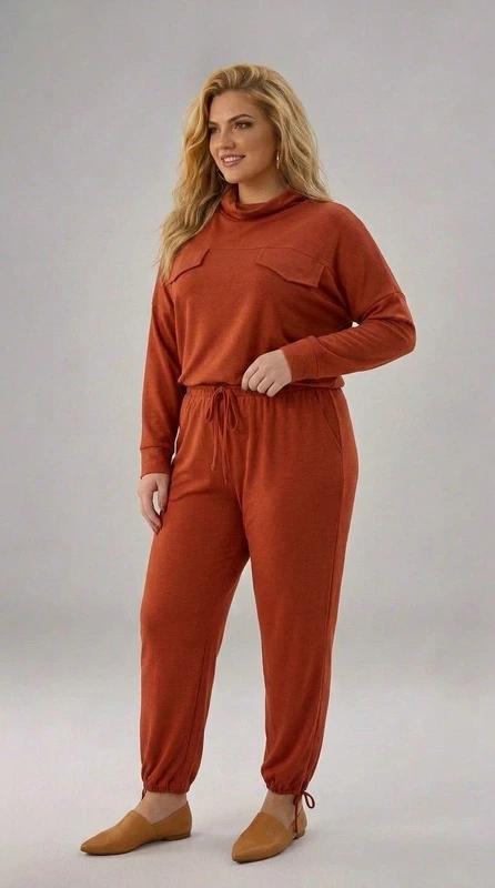 Σετ παντελόνι και μπλούζα εκάι - SET133 | Candiashop Boutique, Αυτό το μοντέρνο σετ σε έντονο κεραμιδί-κόκκινο χρώμα συνδυάζει άνεση και στυλ για την καθημερινή σας εμφάνιση. Η μπλούζα με τη χαλαρή γραμμή διαθέτει μακριά μανίκια και ξεχωριστές διακοσμητικές τσέπες στο μπροστινό μέρος που προσθέτουν ενδιαφέρον στο σχέδιο. Το παντελόνι με την άνετη ελαστική μέση και κορδόνι προσφέρει εξαιρετική εφαρμογή, ενώ το σχέδιο με τα σφιγμένα τελειώματα στους αστραγάλους δημιουργεί έναν κολακευτικό όγκο. Το σύνολο είναι κατασκευασμένο από μαλακό, ελαστικό ύφασμα που αγκαλιάζει το σώμα χωρίς να περιορίζει τις κινήσεις, ιδανικό για χαλαρές εξόδους ή άνετες στιγμές στο σπίτι. Συνδυάστε το με μποτάκια σε ταμπά απόχρωση, όπως φαίνεται στην εικόνα, ή με αθλητικά παπούτσια για μια πιο casual εμφάνιση. Το έντονο χρώμα του προσθέτει ζωντάνια στη γκαρνταρόμπα σας και είναι ιδανικό για τη φθινοπωρινή και χειμερινή περίοδο. Η απλή αλλά προσεγμένη σχεδίαση το καθιστά διαχρονικό κομμάτι που θα απολαμβάνετε για πολλές σεζόν.