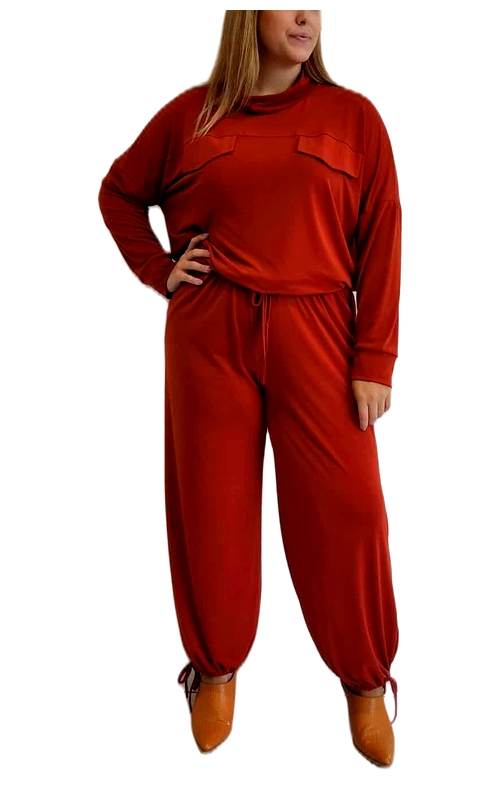 Αυτό το μοντέρνο σετ σε έντονο κεραμιδί\u002Dκόκκινο χρώμα συνδυάζει άνεση και στυλ για την καθημερινή σας εμφάνιση. Η μπλούζα με τη χαλαρή γραμμή διαθέτει μακριά μανίκια και ξεχωριστές διακοσμητικές τσέπες στο μπροστινό μέρος που προσθέτουν ενδιαφέρον στο σχέδιο. Το παντελόνι με την άνετη ελαστική μέση και κορδόνι προσφέρει εξαιρετική εφαρμογή, ενώ το σχέδιο με τα σφιγμένα τελειώματα στους αστραγάλους δημιουργεί έναν κολακευτικό όγκο. Το σύνολο είναι κατασκευασμένο από μαλακό, ελαστικό ύφασμα που αγκαλιάζει το σώμα χωρίς να περιορίζει τις κινήσεις, ιδανικό για χαλαρές εξόδους ή άνετες στιγμές στο σπίτι. Συνδυάστε το με μποτάκια σε ταμπά απόχρωση, όπως φαίνεται στην εικόνα, ή με αθλητικά παπούτσια για μια πιο casual εμφάνιση. Το έντονο χρώμα του προσθέτει ζωντάνια στη γκαρνταρόμπα σας και είναι ιδανικό για τη φθινοπωρινή και χειμερινή περίοδο. Η απλή αλλά προσεγμένη σχεδίαση το καθιστά διαχρονικό κομμάτι που θα απολαμβάνετε για πολλές σεζόν.