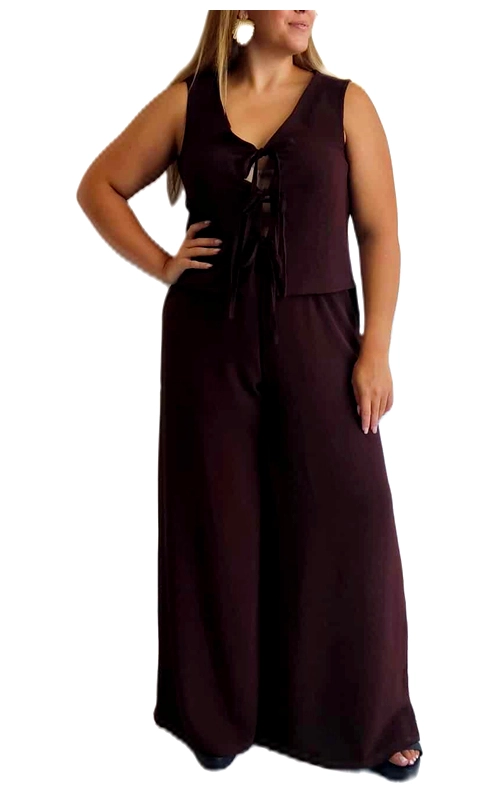 Αυτή η κομψή ολόσωμη φόρμα σε βαθύ μπορντό χρώμα συνδυάζει άνεση και στυλ για κάθε περίσταση. Η αμάνικη σχεδίαση με το V λαιμόκοψη και τη διακοσμητική δέση στο μπροστινό μέρος προσθέτει μια θηλυκή πινελιά στο σύνολο. Η φαρδιά γραμμή του παντελονιού χαρίζει ελευθερία κινήσεων και μια αέρινη αίσθηση, ενώ η ψηλή μέση κολακεύει τη σιλουέτα. Το απαλό, ρέον ύφασμα αγκαλιάζει το σώμα με χάρη, καθιστώντας αυτή τη φόρμα ιδανική τόσο για βραδινές εξόδους όσο και για πιο casual περιστάσεις. Μπορεί να φορεθεί με ψηλοτάκουνα πέδιλα για ένα εντυπωσιακό βραδινό λουκ ή με flat σανδάλια για μια πιο χαλαρή εμφάνιση. Συνδυάστε τη με μια λεπτή ζώνη στη μέση για να τονίσετε τη σιλουέτα σας ή με ένα κοντό σακάκι για τις πιο δροσερές βραδιές. Η διαχρονική απόχρωση και η άνετη εφαρμογή καθιστούν αυτή τη φόρμα ένα απαραίτητο κομμάτι για κάθε γυναικεία γκαρνταρόμπα.