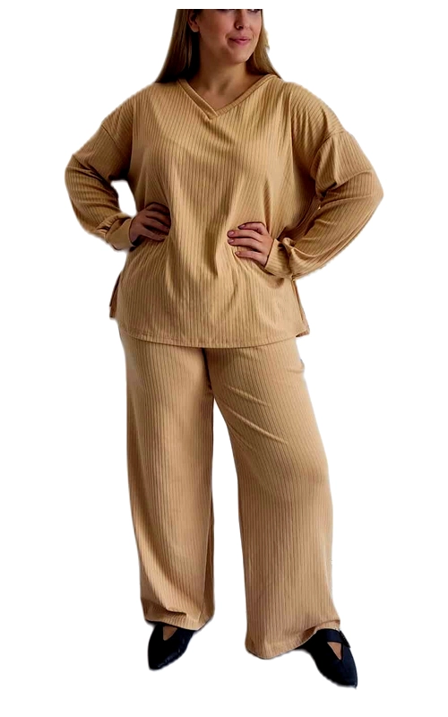 Αυτό το κομψό σετ πλεκτό σε απαλό καφέ\u002Dμπεζ (camel) χρώμα συνδυάζει άνεση και στυλ για τις καθημερινές σας εμφανίσεις. Το σύνολο αποτελείται από μια φαρδιά μπλούζα με V λαιμόκοψη και φαρδύ παντελόνι, και τα δύο με διακριτικό ριμπ πλέξιμο που προσθέτει υφή και ενδιαφέρον. Η μπλούζα διαθέτει χαλαρή γραμμή με άνετα μανίκια που επιτρέπουν ελευθερία κινήσεων, ενώ το παντελόνι με την ίσια, φαρδιά γραμμή χαρίζει κομψότητα και άνεση. Ιδανικό για χαλαρές εξόδους, για το σπίτι ή ακόμα και για casual επαγγελματικές εμφανίσεις, αυτό το σετ μπορεί να φορεθεί με μποτάκια ή γόβες για πιο επίσημο look, όπως φαίνεται στην εικόνα. Το ουδέτερο χρώμα του επιτρέπει αμέτρητους συνδυασμούς με αξεσουάρ και εξωτερικά ρούχα. Το υλικό προσφέρει μαλακή αίσθηση στο δέρμα, ενώ η χαλαρή εφαρμογή κολακεύει όλους τους σωματότυπους. Ένα διαχρονικό σύνολο που συνδυάζει την πολυτέλεια της άνεσης με την κομψότητα της απλότητας.