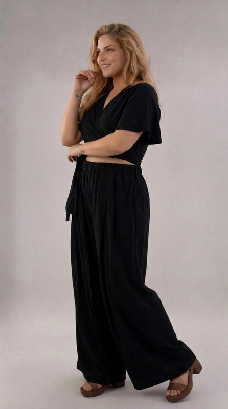 Σετ παντελόνι και μπλούζα μαύρο - SET147 | Candiashop Boutique, Ανακαλύψτε το απόλυτο σετ δύο τεμαχίων σε βαθύ μαύρο χρώμα, που συνδυάζει κομψότητα και άνεση σε ένα μοναδικό σύνολο. Η κροπ μπλούζα με το κρουαζέ σχέδιο και τα φαρδιά μανίκια butterfly δημιουργεί μια θηλυκή και ρομαντική σιλουέτα, ενώ το δέσιμο στη μέση επιτρέπει την προσαρμογή της εφαρμογής στο σώμα σας. Το παντελόνι με την ελαστική μέση και την palazzo γραμμή χαρίζει απεριόριστη άνεση, ενώ οι πλαϊνές τσέπες προσθέτουν πρακτικότητα στο σύνολο. Το λείο, ρέον ύφασμα κινείται χαριτωμένα με κάθε βήμα, δημιουργώντας μια εντυπωσιακή εμφάνιση. Το αμιγώς μαύρο χρώμα το καθιστά ευέλικτο και διαχρονικό, κατάλληλο για καλοκαιρινές βόλτες, ρομαντικά ραντεβού, αλλά και για πιο επίσημες περιστάσεις. Μπορεί να φορεθεί με ψηλοτάκουνα πέδιλα για βραδινή έξοδο ή με flat σανδάλια για έναν πιο casual, καθημερινό look. Ένα σετ που αξίζει να έχετε στη γκαρνταρόμπα σας!