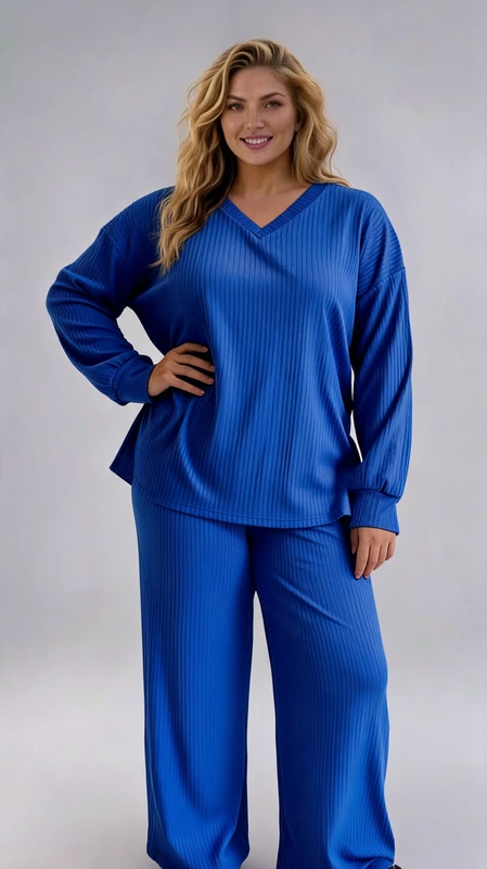 Σετ παντελόνι και μπλούζα μπλε - SET128 | Candiashop Boutique, Κομψό σετ πιτζάμας ή φόρμας σε ζωηρό βασιλικό μπλε χρώμα, ιδανικό για άνετες στιγμές στο σπίτι. Η μπλούζα διαθέτει κλασικό V λαιμό και φαρδιά μακριά μανίκια που προσφέρουν άνεση στις κινήσεις, ενώ το ριμπ πλεκτό ύφασμα με τις διακριτικές κάθετες γραμμές προσδίδει κομψότητα και στυλ. Το παντελόνι έχει φαρδιά γραμμή που χαρίζει απόλυτη άνεση, με ελαστική μέση για εύκολη εφαρμογή σε κάθε σωματότυπο. Το σετ είναι κατασκευασμένο από μαλακό, απαλό ύφασμα που αγκαλιάζει το σώμα, ιδανικό τόσο για τις βραδινές ώρες χαλάρωσης όσο και για casual εμφανίσεις εντός σπιτιού. Μπορεί να συνδυαστεί με μαλακές παντόφλες για την απόλυτη αίσθηση άνεσης ή ακόμη και με casual παπούτσια για σύντομες εξόδους. Η μονόχρωμη σύνθεση και το διαχρονικό στυλ το καθιστούν ιδανική επιλογή για όλες τις εποχές, προσφέροντας κομψότητα χωρίς να θυσιάζει την άνεση.