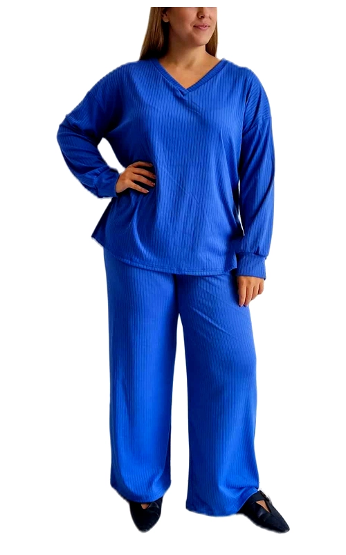 Κομψό σετ πιτζάμας ή φόρμας σε ζωηρό βασιλικό μπλε χρώμα, ιδανικό για άνετες στιγμές στο σπίτι. Η μπλούζα διαθέτει κλασικό V λαιμό και φαρδιά μακριά μανίκια που προσφέρουν άνεση στις κινήσεις, ενώ το ριμπ πλεκτό ύφασμα με τις διακριτικές κάθετες γραμμές προσδίδει κομψότητα και στυλ. Το παντελόνι έχει φαρδιά γραμμή που χαρίζει απόλυτη άνεση, με ελαστική μέση για εύκολη εφαρμογή σε κάθε σωματότυπο. Το σετ είναι κατασκευασμένο από μαλακό, απαλό ύφασμα που αγκαλιάζει το σώμα, ιδανικό τόσο για τις βραδινές ώρες χαλάρωσης όσο και για casual εμφανίσεις εντός σπιτιού. Μπορεί να συνδυαστεί με μαλακές παντόφλες για την απόλυτη αίσθηση άνεσης ή ακόμη και με casual παπούτσια για σύντομες εξόδους. Η μονόχρωμη σύνθεση και το διαχρονικό στυλ το καθιστούν ιδανική επιλογή για όλες τις εποχές, προσφέροντας κομψότητα χωρίς να θυσιάζει την άνεση.