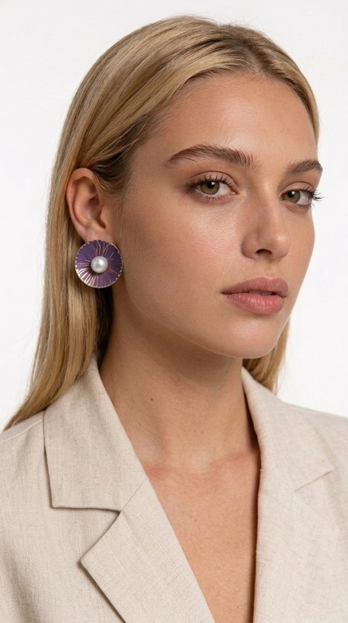Σκουλαρίκια καρφωτά με πέρλες σε μοβ - SKOUL-4760 | Candiashop Boutique, Τα καρφωτά σκουλαρίκια με πέρλες σε μοβ απόχρωση είναι μια κομψή επιλογή που συνδυάζει την αίσθηση της vintage αισθητικής με το μοντέρνο σχεδιασμό. Σχεδιασμένα από την Ελληνίδα Σχεδιάστρια Κοσμημάτων Αικατερίνη Χαλκιαδάκη, αυτά τα χειροποίητα σκουλαρίκια αποτελούν μια ξεχωριστή προσθήκη στη συλλογή κάθε γυναίκας που αγαπά τα αυθεντικά κοσμήματα.
Η κυκλική φόρμα με τη ραβδωτή επιφάνεια από ορείχαλκο, καλυμμένη με βαθύ μοβ σμάλτο, αναδεικνύει στο κέντρο μια λαμπερή πέρλα, δημιουργώντας ένα αποτέλεσμα που θυμίζει ανθισμένο λουλούδι. Η εκλεπτυσμένη αυτή σύνθεση ταιριάζει εξίσου σε καθημερινά ντυσίματα αλλά και σε επίσημες εμφανίσεις, από εταιρικές συναντήσεις μέχρι γάμους και βαφτίσια.
Τα σκουλαρίκια με πέρλες σε μοβ χρώμα είναι ιδανικά για δώρο σε αγαπημένα πρόσωπα, καθώς έρχονται χειροποίητα με προσοχή στη λεπτομέρεια και ποιοτικά υλικά που εξασφαλίζουν μακροχρόνια χρήση.
