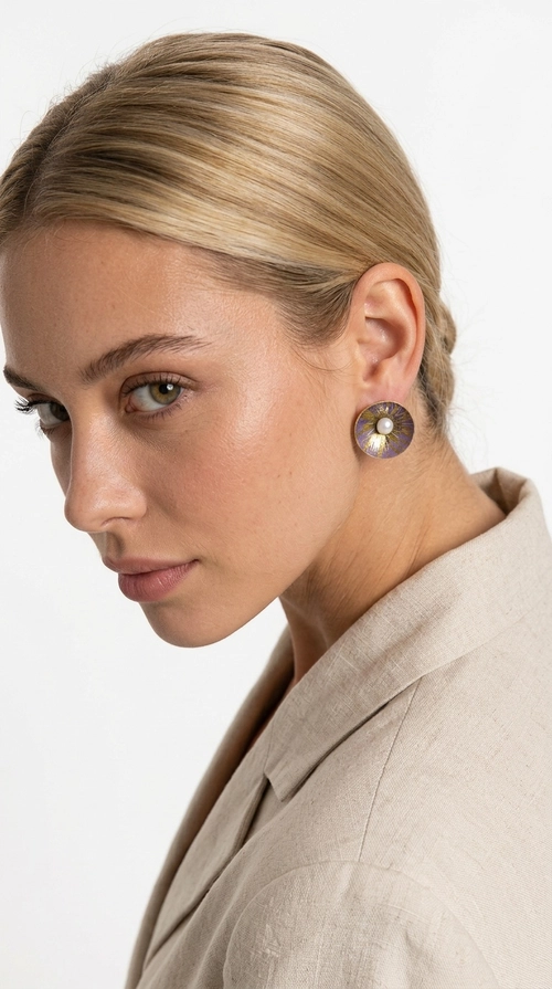Σκουλαρίκια καρφωτά με πέρλες σε μοβ - SKOUL-4761 | Candiashop Boutique, Τα χειροποίητα καρφωτά σκουλαρίκια με πέρλες σε μοβ αποτελούν μια κομψή επιλογή για κάθε γυναίκα που αναζητά κοσμήματα με χαρακτήρα και αίσθηση. Σχεδιασμένα από την Ελληνίδα Σχεδιάστρια Κοσμημάτων Αικατερίνη Χαλκιαδάκη, αυτά τα μοναδικά σκουλαρίκια συνδυάζουν την εκλεπτυσμένη αισθητική με την ανθεκτικότητα του ορείχαλκου και τη ζεστασιά του χειροποίητου σμάλτου, δημιουργώντας ένα αποτέλεσμα που ξεχωρίζει.
Κάθε ζευγάρι διαθέτει κυκλική φόρμα σε λιλά-μοβ απόχρωση με χρυσές χάλκινες λεπτομέρειες, ενώ στο κέντρο δεσπόζει μια φυσική πέρλα που προσδίδει γοητεία και θηλυκότητα. Η ματ υφή του σμάλτου σε συνδυασμό με την απαλή λάμψη της πέρλας δημιουργεί μια αντίθεση που κάνει το κόσμημα να ξεχωρίζει τόσο σε καθημερινό look όσο και σε επίσημες εμφανίσεις, γάμους και βαφτίσια.
Ιδανικά για δώρο ή προσωπική χρήση, ταιριάζουν με minimal ντύσιμο, casual στυλ αλλά και με επίσημες εμφανίσεις. Η ελαφριά κατασκευή τους εξασφαλίζει άνεση σε καθημερινή χρήση.
