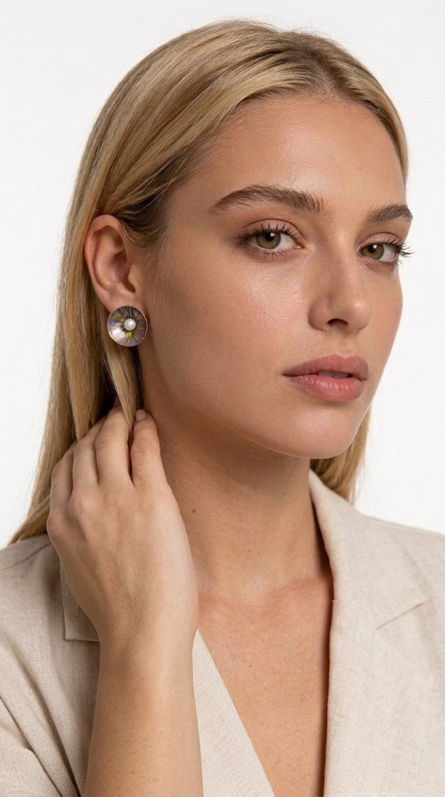 Σκουλαρίκια καρφωτά με πέρλες σε μοβ - SKOUL-4761 | Candiashop Boutique, Τα χειροποίητα καρφωτά σκουλαρίκια με πέρλες σε μοβ αποτελούν μια κομψή επιλογή για κάθε γυναίκα που αναζητά κοσμήματα με χαρακτήρα και αίσθηση. Σχεδιασμένα από την Ελληνίδα Σχεδιάστρια Κοσμημάτων Αικατερίνη Χαλκιαδάκη, αυτά τα μοναδικά σκουλαρίκια συνδυάζουν την εκλεπτυσμένη αισθητική με την ανθεκτικότητα του ορείχαλκου και τη ζεστασιά του χειροποίητου σμάλτου, δημιουργώντας ένα αποτέλεσμα που ξεχωρίζει.
Κάθε ζευγάρι διαθέτει κυκλική φόρμα σε λιλά-μοβ απόχρωση με χρυσές χάλκινες λεπτομέρειες, ενώ στο κέντρο δεσπόζει μια φυσική πέρλα που προσδίδει γοητεία και θηλυκότητα. Η ματ υφή του σμάλτου σε συνδυασμό με την απαλή λάμψη της πέρλας δημιουργεί μια αντίθεση που κάνει το κόσμημα να ξεχωρίζει τόσο σε καθημερινό look όσο και σε επίσημες εμφανίσεις, γάμους και βαφτίσια.
Ιδανικά για δώρο ή προσωπική χρήση, ταιριάζουν με minimal ντύσιμο, casual στυλ αλλά και με επίσημες εμφανίσεις. Η ελαφριά κατασκευή τους εξασφαλίζει άνεση σε καθημερινή χρήση.
