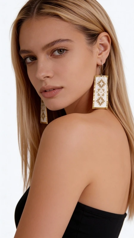 Κεντητά σκουλαρίκια statement με γεωμετρικά σχέδια από χρυσοκλωστή σε λευκό - SKOUL-4692, Αυτά τα εντυπωσιακά statement σκουλαρίκια κεντητά με χρυσοκλωστή συνδυάζουν την παραδοσιακή τέχνη του κεντήματος με τη σύγχρονη αισθητική. Σχεδιασμένα από την Ελληνίδα Σχεδιάστρια Κοσμημάτων Αικατερίνη Χαλκιαδάκη, αυτά τα χειροποίητα σκουλαρίκια διακοσμούνται με γεωμετρικά μοτίβα σε λευκή βάση που δημιουργούν μια κομψή και διαχρονική εμφάνιση.
Τα κρεμαστά σκουλαρίκια χαρακτηρίζονται από τη λεπτομερή χρυσή κεντητή διακόσμηση που σχηματίζει ρομβοειδή σχέδια, προσφέροντας μια μοναδική υφή και όγκο. Η λευκή βάση δημιουργεί την τέλεια αντίθεση με τις χρυσές λεπτομέρεις, ενώ το ορθογώνιο σχήμα τους τα καθιστά ιδανικά για κάθε περίσταση.
Αυτά τα μοντέρνα κεντητά σκουλαρίκια είναι η τέλεια επιλογή για γυναίκες που αγαπούν τα εντυπωσιακά κοσμήματα με παραδοσιακά στοιχεία. Συνδυάζονται αρμονικά με κλασικά και σύγχρονα outfit, προσθέτοντας μια νότα κομψότητας και πρωτοτυπίας. Φυλάσσετε σε στεγνό μέρος και καθαρίζετε απαλά με στεγνό πανί.
Υλικό: Ορείχαλκος, Ύφασμα