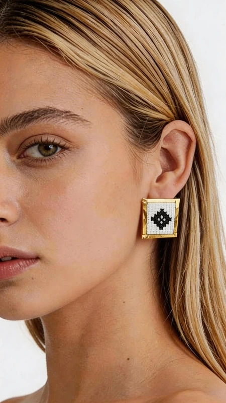 Κεντητά σκουλαρίκια statement με γεωμετρικά σχέδια από χρυσοκλωστή σε άσπρο - SKOUL-4715 | Candiashop Boutique, Ξεχωρίστε με αυτά τα εντυπωσιακά statement σκουλαρίκια κεντητά με γεωμετρικά σχέδια σε λευκό χρώμα, που συνδυάζουν την παραδοσιακή τέχνη της χρυσοκλωστής με σύγχρονο design. Σχεδιασμένα από την Ελληνίδα Σχεδιάστρια Κοσμημάτων Αικατερίνη Χαλκιαδάκη, αυτά τα χειροποίητα σκουλαρίκια αποτελούν την τέλεια επιλογή για κάθε γυναίκα που θέλει να εκφράσει την προσωπικότητά της με στυλ. Το κεντητό γεωμετρικό μοτίβο σε λευκό και μαύρο χρώμα δημιουργεί έναν εντυπωσιακό οπτικό αντίπαλο που προσελκύει τα βλέμματα. Η χρυσή βάση προσδίδει πολυτέλεια και κομψότητα, ενώ το τετράγωνο σχήμα τους τα καθιστά ιδανικά για μοντέρνες εμφανίσεις. Αυτά τα statement σκουλαρίκια συνδυάζονται τέλεια με επαγγελματικά outfits, casual εμφανίσεις ή και γαμήλιες τελετές. Υλικό: Ορείχαλκος, Ύφασμα Συντηρήστε τα σκουλαρίκια σας φυλάσσοντάς τα σε στεγνό μέρος και καθαρίζοντάς τα απαλά με μαλακό πανί. Αποφύγετε την επαφή με αρώματα και υγρασία για να διατηρήσετε την ομορφιά τους για χρόνια.