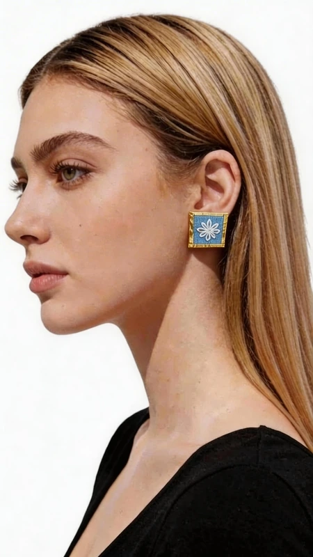 Κεντητά σκουλαρίκια statement με γεωμετρικά σχέδια από χρυσοκλωστή σε γαλάζιο - SKOUL-4719 | Candiashop Boutique, Ανακαλύψτε τη μαγεία των κεντητών statement σκουλαρικιών με γεωμετρικά σχέδια από χρυσοκλωστή σε εντυπωσιακό γαλάζιο χρώμα. Αυτά τα εξαιρετικά χειροποίητα σκουλαρίκια, σχεδιασμένα από την Ελληνίδα Σχεδιάστρια Κοσμημάτων Αικατερίνη Χαλκιαδάκη, συνδυάζουν την παραδοσιακή τέχνη του κεντήματος με σύγχρονη αισθητική. Το κάθε σκουλαρίκι διακοσμείται με περίτεχνα γεωμετρικά μοτίβα που κεντήθηκαν με χρυσή κλωστή σε έντονο γαλάζιο υπόβαθρο, δημιουργώντας ένα μοναδικό κέντημα που θυμίζει την ελληνική παραδοσιακή τέχνη. Η τετράγωνη φόρμα και το χρυσό περίγραμμα προσθέτουν μία κομψή νότα που κάνει αυτά τα εντυπωσιακά σκουλαρίκια ιδανικά για κάθε περίσταση. Τα statement σκουλαρίκια αυτά είναι τέλεια για να συμπληρώσουν ένα νυφικό look, έναν επίσημο εορταστικό εμφανισμό ή ακόμα και ένα casual σύνολο που θέλετε να ξεχωρίσει. Η υψηλή ποιότητα κατασκευής και το πρωτότυπο σχέδιο τα καθιστούν ένα μοναδικό κομμάτι που θα απογειώσει το στυλ σας. Υλικό: Ορείχαλκος, Ύφασμα Φροντίστε τα με προσοχή, αποφεύγοντας την επαφή με νερό και αρώματα για τη διατήρηση των χρωμάτων.