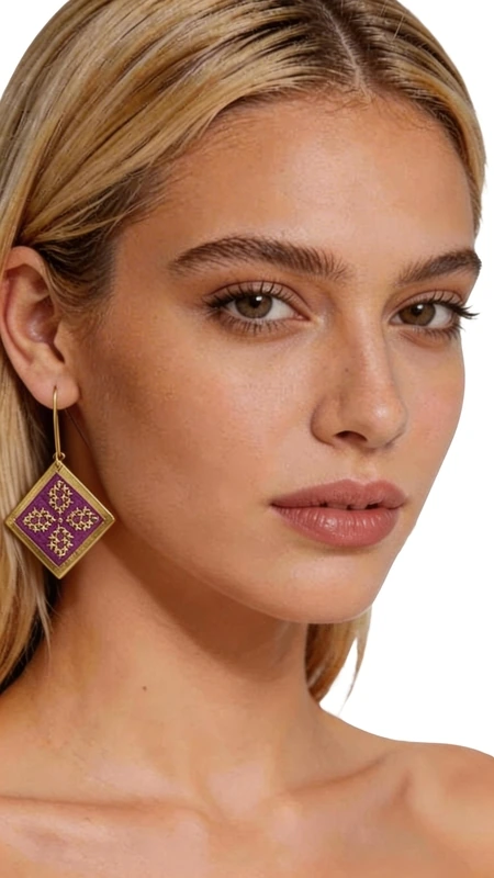 Τα κεντητά statement σκουλαρίκια με χρυσοκλωστή σε έντονο μπορντό χρώμα αποτελούν την τέλεια επιλογή για γυναίκες που αγαπούν τα εντυπωσιακά κοσμήματα. Σχεδιασμένα από την Ελληνίδα Σχεδιάστρια Κοσμημάτων Αικατερίνη Χαλκιαδάκη, αυτά τα χειροποίητα σκουλαρίκια συνδυάζουν παραδοσιακή τεχνική κεντήματος με σύγχρονο γεωμετρικό design. Η τετραγωνική τους φόρμα με τα περίτεχνα γεωμετρικά μοτίβα δημιουργεί ένα boho\u002Dchic στυλ που ολοκληρώνει τόσο καθημερινά όσο και επίσημα look. Τα κρεμαστά σκουλαρίκια είναι κατασκευασμένα με υψηλής ποιότητας χρυσή κλωστή που δημιουργεί λαμπερές αντανακλάσεις, ενώ το βαθύ μπορντό χρώμα προσθέτει elegance και θηλυκότητα. Το κάθε σκουλαρίκι είναι χειροκέντητο με απόλυτη ακρίβεια, αποτελώντας ένα πραγματικό έργο τέχνης που φοριέται. Τα statement εξαρτήματα είναι ιδανικά για γάμους, βραδινές εξόδους ή όταν θέλετε να προσθέσετε έναν εντυπωσιακό τόνο στο σύνολό σας. Υλικό: Ορείχαλκος, Ύφασμα Φροντίστε τα προσεκτικά, αποθηκεύοντάς τα σε στεγνό χώρο μακριά από υγρασία. Καθαρίστε απαλά με μαλακό πανί όταν χρειάζεται.