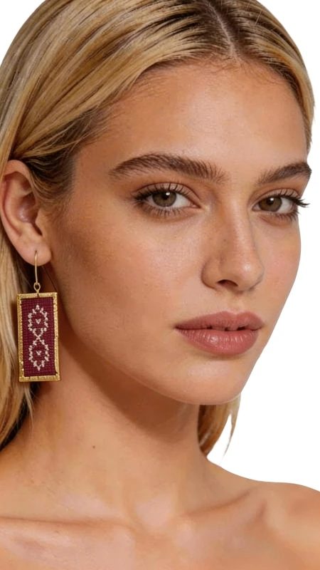 Τα statement κεντητά σκουλαρίκια με γεωμετρικά σχέδια σε μπορντό χρώμα αποτελούν τον τέλειο συνδυασμό παραδοσιακής τέχνης και σύγχρονης αισθητικής. Κατασκευασμένα από χρυσοκλωστή υψηλής ποιότητας, αυτά τα εντυπωσιακά σκουλαρίκια έχουν σχεδιαστεί από την Ελληνίδα Σχεδιάστρια Κοσμημάτων Αικατερίνη Χαλκιαδάκη, αποτυπώνοντας την αυθεντική ελληνική κοσμηματοτεχνία. Τα ορθογώνια κεντητά σκουλαρίκια διαθέτουν πολύπλοκα γεωμετρικά μοτίβα που δημιουργούν μια εκλεπτυσμένη vintage αισθητική. Το βαθύ μπορντό χρώμα συνδυάζεται αρμονικά με τις χρυσές λεπτομέρειες, δημιουργώντας ένα luxurious αποτέλεσμα που ταιριάζει τέλεια σε κάθε περίσταση. Η χειροποίητη κατασκευή εγγυάται την μοναδικότητα κάθε κομματιού, ενώ το ελαφρύ τους βάρος τα καθιστά ιδανικά για όλη την ημέρα. Αυτά τα boho σκουλαρίκια αποτελούν την τέλεια επιλογή για γάμους, ειδικές εκδηλώσεις ή για να προσθέσετε μια δόση κομψότητας στην καθημερινότητά σας. Υλικό: Ορείχαλκος, Ύφασμα Φροντίστε τα σκουλαρίκιά σας αποφεύγοντας την επαφή με νερό και αρώματα. Φυλάσσετε τα σε στεγνό μέρος για να διατηρήσετε τη λάμψη τους.