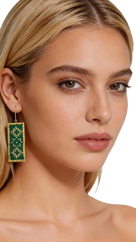 Ξεχωρίστε με αυτά τα εντυπωσιακά statement σκουλαρίκια που συνδυάζουν την παραδοσιακή τέχνη του κεντήματος με μοντέρνο design. Σχεδιασμένα από την Ελληνίδα Σχεδιάστρια Κοσμημάτων Αικατερίνη Χαλκιαδάκη, αυτά τα μοναδικά κεντητά σκουλαρίκια σε έντονο πράσινο χρώμα αποτελούν την τέλεια επιλογή για κάθε ξεχωριστή εμφάνιση. Τα ορθογώνια σκουλαρίκια διακοσμούνται με γεωμετρικά μοτίβα κεντημένα με χρυσοκλωστή, δημιουργώντας έναν εκλεπτυσμένο συνδυασμό χρωμάτων που ταιριάζει τόσο στις καθημερινές όσο και στις επίσημες εμφανίσεις. Η χειροποίητη κατασκευή εξασφαλίζει τη μοναδικότητα κάθε κομματιού, ενώ το ελαφρύ τους βάρος τα καθιστά ιδιαίτερα άνετα στη χρήση. Υλικό: Ορείχαλκος, Ύφασμα Για τη διατήρηση των χρωμάτων και της ποιότητας, φυλάσσετε τα σκουλαρίκια σε στεγνό μέρος και αποφεύγετε την επαφή με υγρασία και χημικές ουσίες.