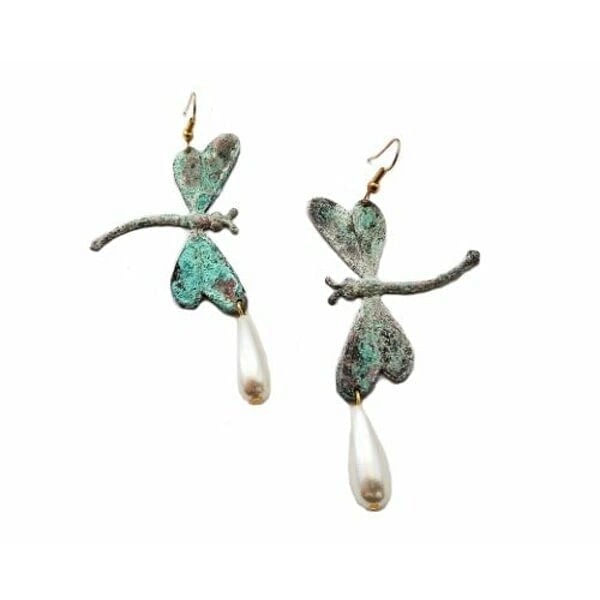 Κρεμαστά σκουλαρίκια λιβελούλες με πέρλες χειροποίητα - 3006, Ανακαλύψτε τη μαγεία της φύσης με αυτά τα εντυπωσιακά κρεμαστά σκουλαρίκια λιβελούλες, σχεδιασμένα από την Ελληνίδα Σχεδιάστρια Κοσμημάτων Αικατερίνη Χαλκιαδάκη. Τα μοναδικά αυτά χειροποίητα κοσμήματα συνδυάζουν την κομψότητα των φυσικών μαργαριταριών με τη βοημιακή αισθητική του οξειδωμένου ορείχαλκου.
Κάθε λιβελούλα έχει δημιουργηθεί με απόλυτη προσοχή στη λεπτομέρεια, παρουσιάζοντας υπέροχες αποχρώσεις πράσινου που δημιουργούν μια vintage patina επίδραση. Οι φυσικές πέρλες που κρέμονται κομψά στο κάτω μέρος προσδίδουν μια αίσθηση luxury και θηλυκότητας, ενώ ο χειροποίητος χαρακτήρας κάνει κάθε ζευγάρι μοναδικό.
Αυτά τα statement σκουλαρίκια είναι ιδανικά για ιδιαίτερες περιστάσεις, boho chic εμφανίσεις ή ως το τέλειο νυφικό αξεσουάρ για μια εναλλακτική νύφη που αγαπά την πρωτοτυπία.