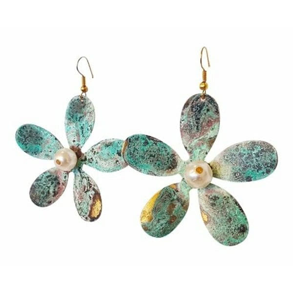 Μεγάλα εντυπωσιακά κρεμαστά σκουλαρίκια με πέρλες που συνδυάζουν το boho στιλ με τη σύγχρονη αισθητική. Αυτά τα μοναδικά χειροποίητα γυναικεία σκουλαρίκια λουλούδια, σχεδιασμένα από την Ελληνίδα Σχεδιάστρια Κοσμημάτων Αικατερίνη Χαλκιαδάκη, ξεχωρίζουν για τη μοντέρνα patina επίστρωση που δημιουργεί εντυπωσιακούς πράσινους τόνους με χρυσαφένιες πινελιές.\u000AΚάθε σκουλαρίκι διαμορφώνεται σε σχήμα μαργαρίτας με έξι οβάλ πέταλα από οξειδωμένο ορείχαλκο, ενώ στο κέντρο φιλοξενεί μία φυσική πέρλα που προσδίδει κομψότητα και φως. Η τεχνική του οξειδωμένου χαλκού δίνει μοναδικούς χρωματισμούς που κάνουν κάθε κόσμημα ξεχωριστό. Το μέγεθός τους καθιστά αυτά τα εντυπωσιακά σκουλαρίκια για γάμο ή ειδικές περιστάσεις την ιδανική επιλογή.\u000AΙδανικά για να συνδυαστούν με boho ντυσίματα ή να προσθέσουν χρώμα σε μονόχρωμα outfits.